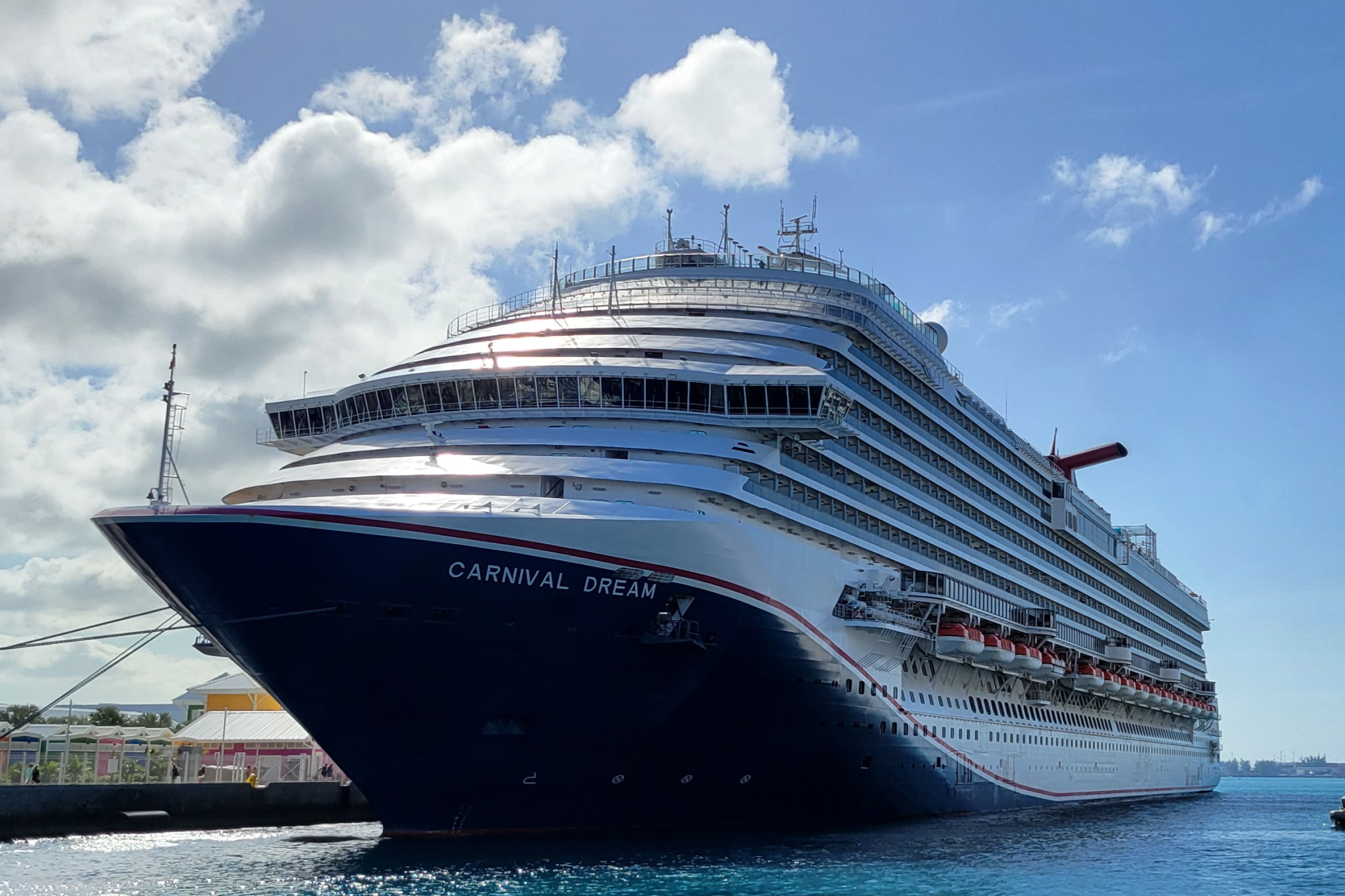 Carnival Cruise Lines Ships by Size image showing Carnival Dream at sea, with its wide hull, evenly stacked balcony cabins, and a busy upper deck filled with pools and open-air spaces