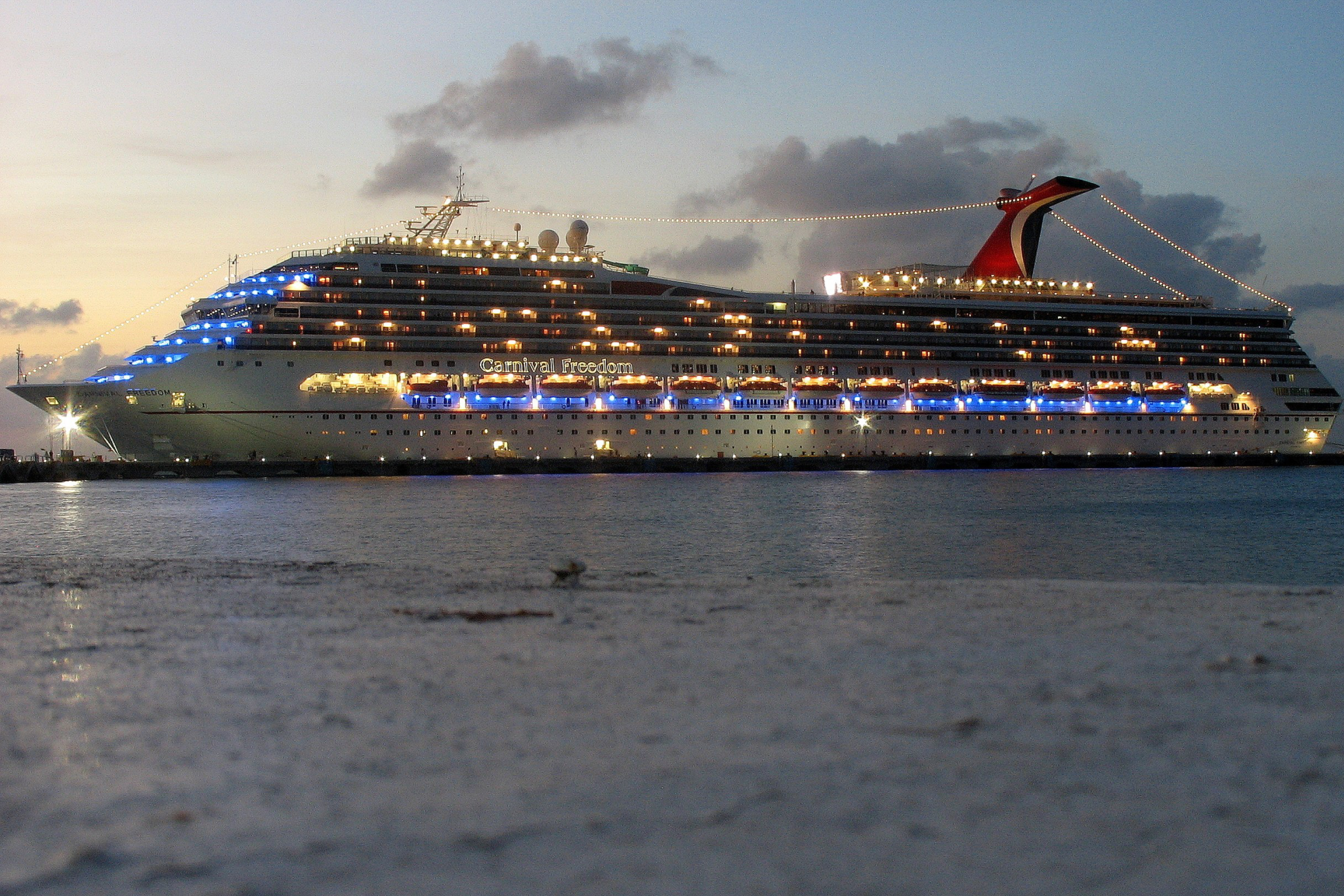 Carnival Cruise Lines Ships by Size photo featuring Carnival Freedom viewed from the side, showing its mid-sized profile, layered decks, and classic cruise ship design