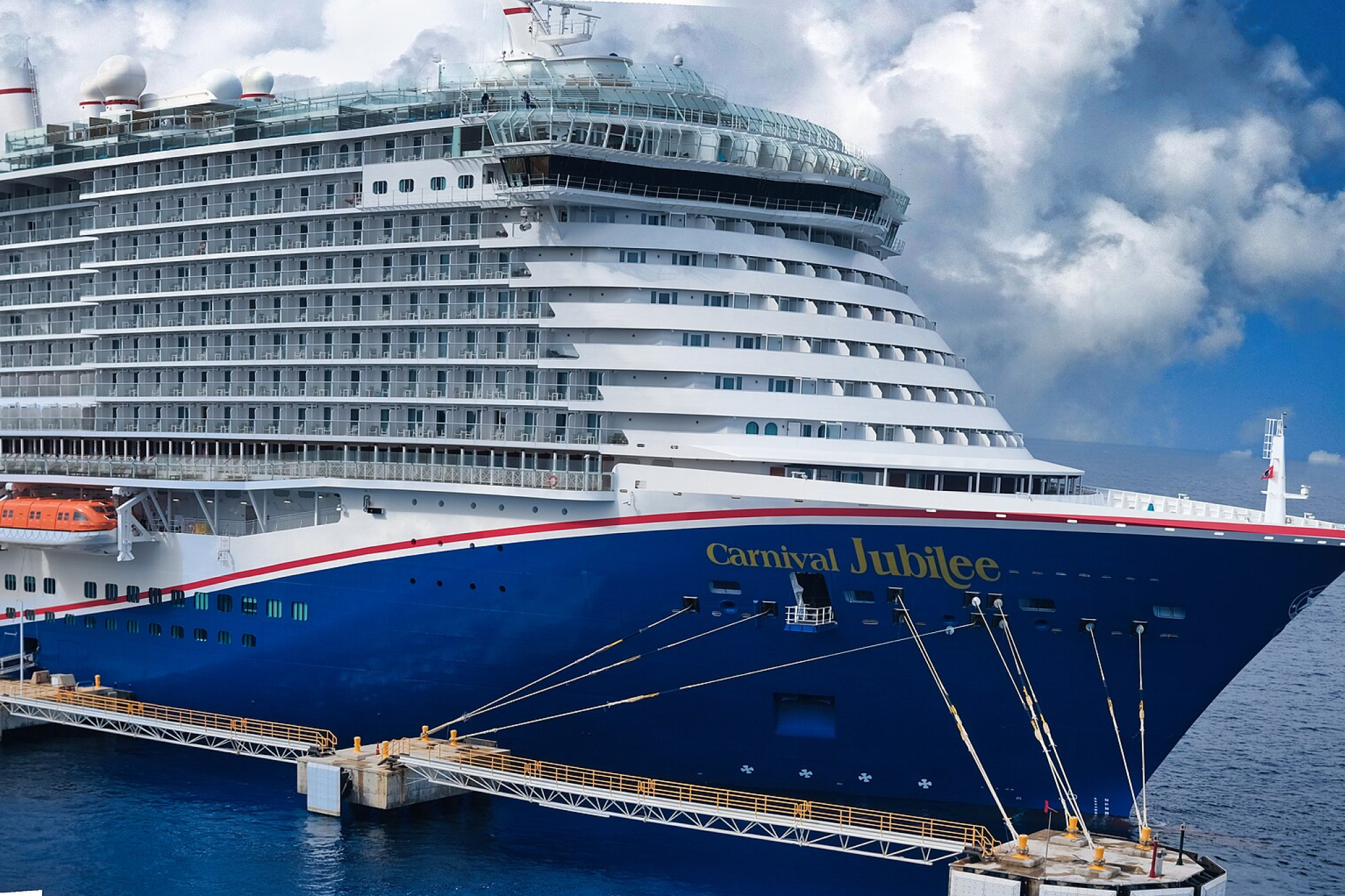 Carnival Cruise Lines Ships by Size comparison featuring Carnival Jubilee, the largest ship in the fleet, shown at sea with its expansive decks, multiple outdoor zones, and Excel Class design visible from above