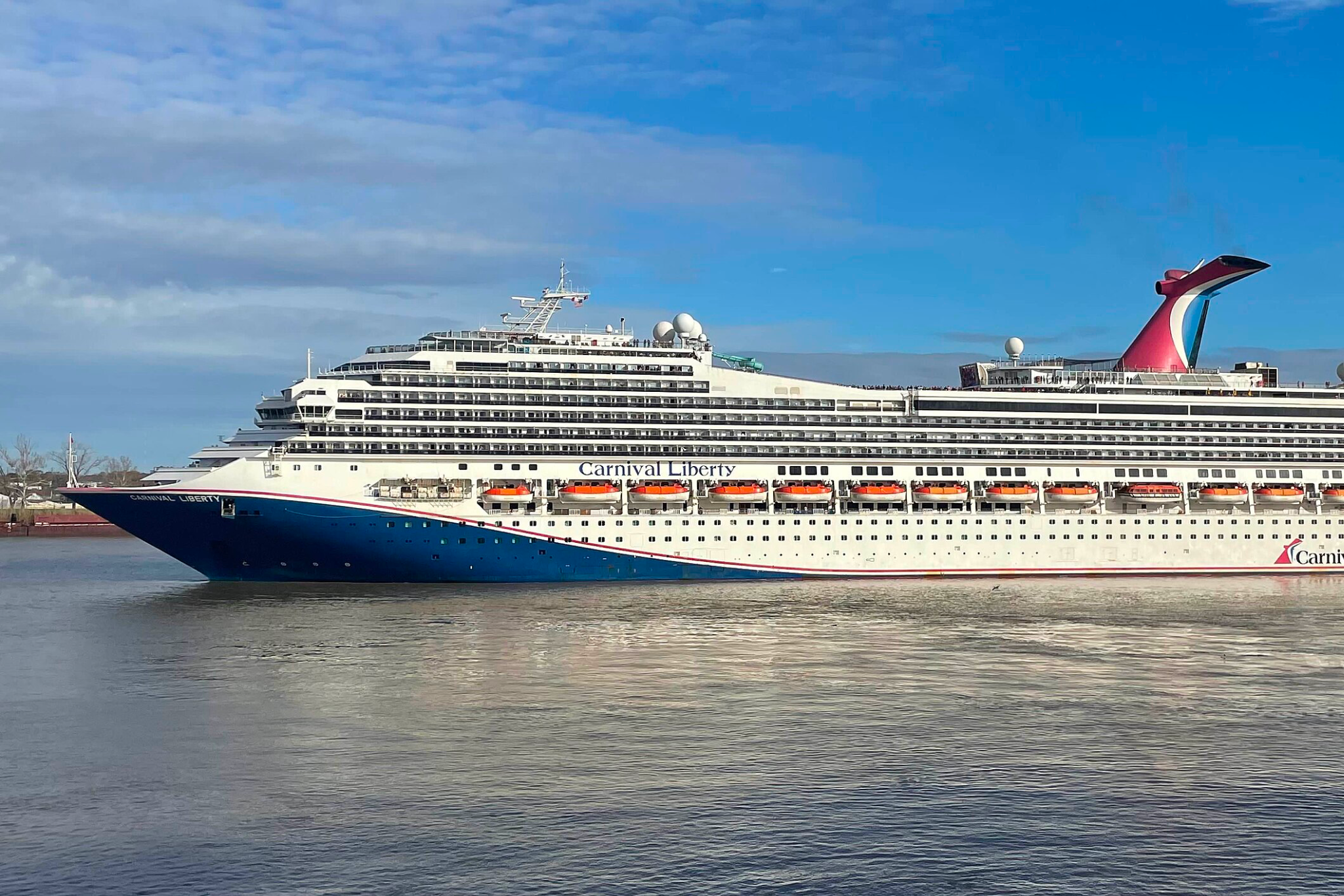 Carnival Cruise Lines Ships by Size image featuring Carnival Liberty cruising near the coast, showing its Conquest Class structure, upper-deck recreation areas, and layered cabins