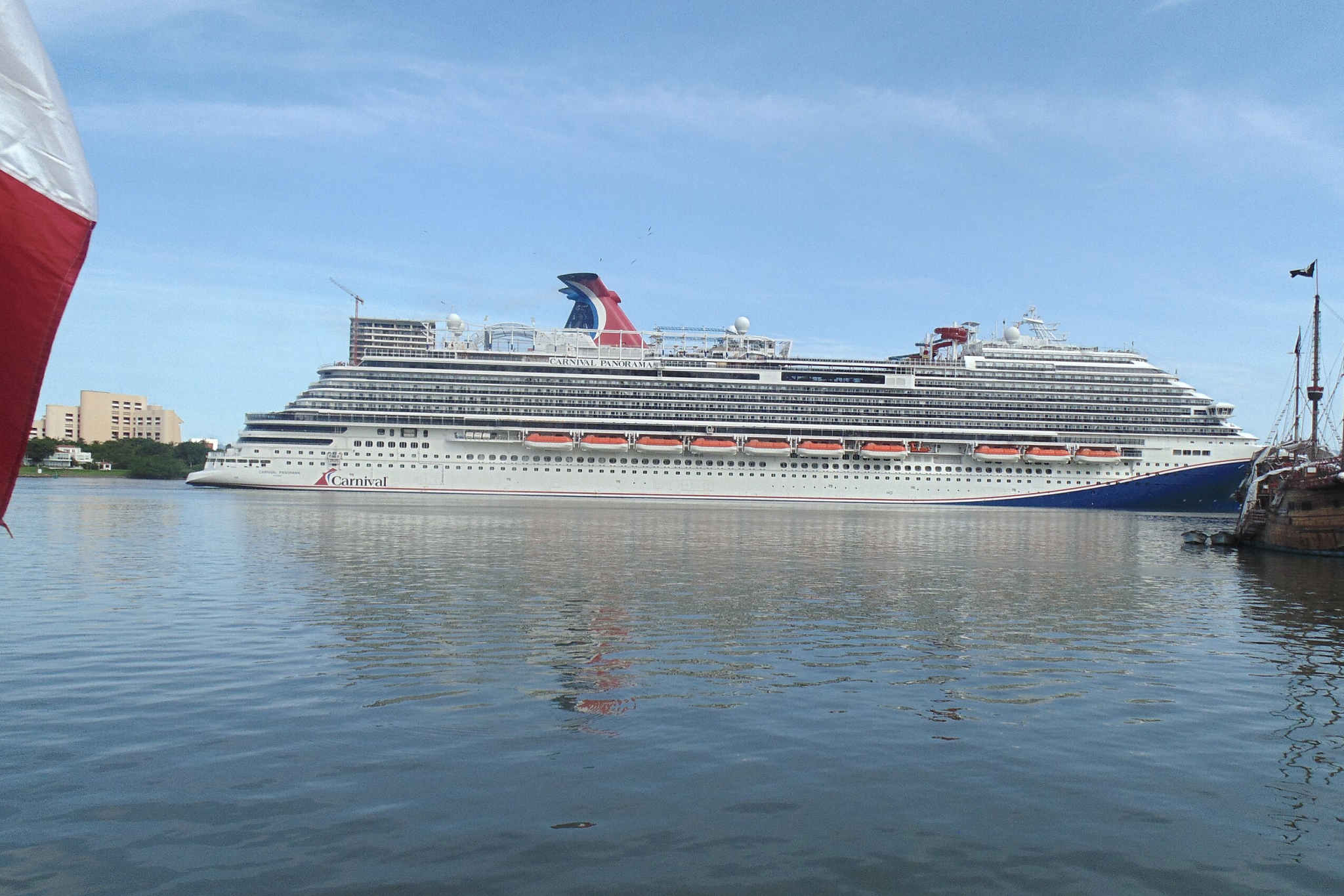 Carnival Cruise Lines Ships by Size illustration of Carnival Panorama underway, with a long Vista Class silhouette, busy upper decks, and activity areas visible along the top levels