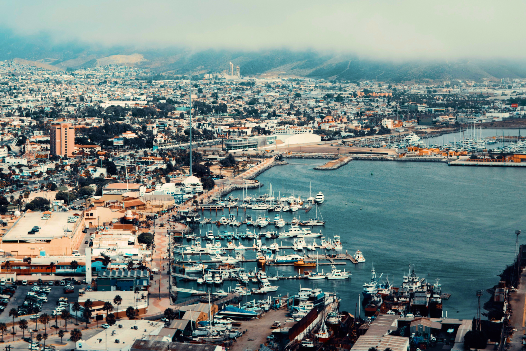 View of the Port of Ensenada, a typical stop on Carnival Firenze’s Mexican Riviera itinerary, showing marina, boats, and coastal cityscape.