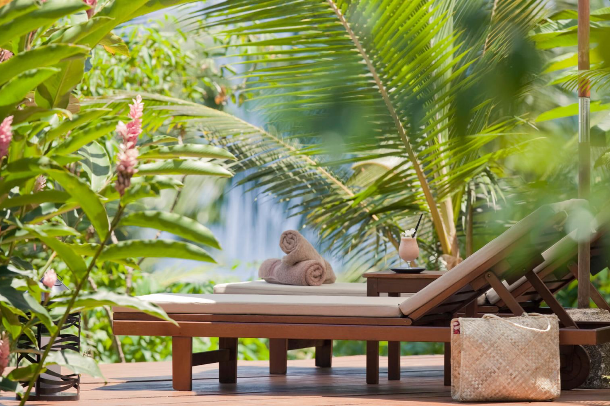 Sun loungers framed by lush tropical foliage at COMO Laucala Island, offering serene privacy and relaxation.