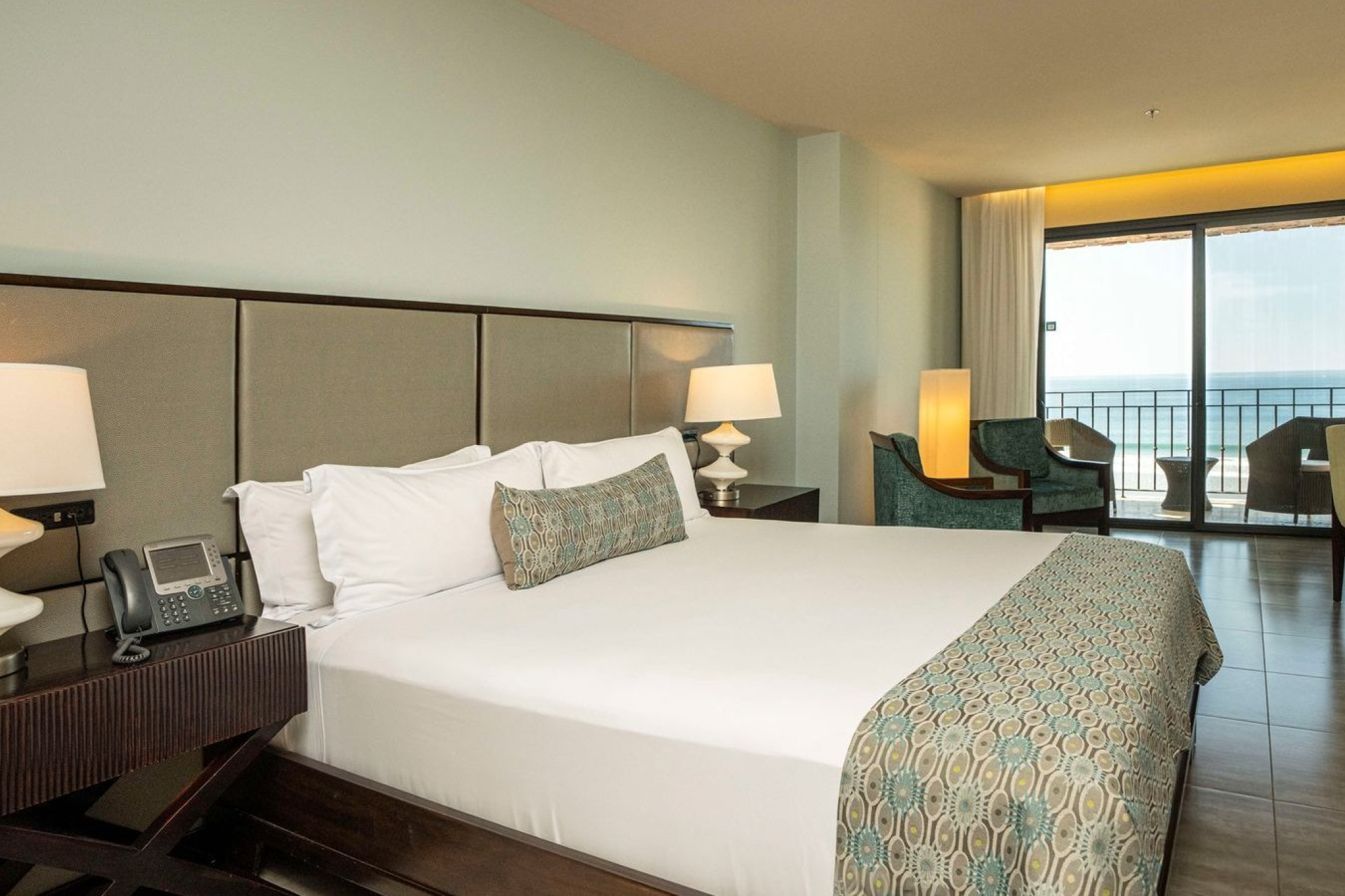 Modern king bedroom at Crocs Resort & Casino featuring ocean views, contemporary furnishings, and a private balcony.