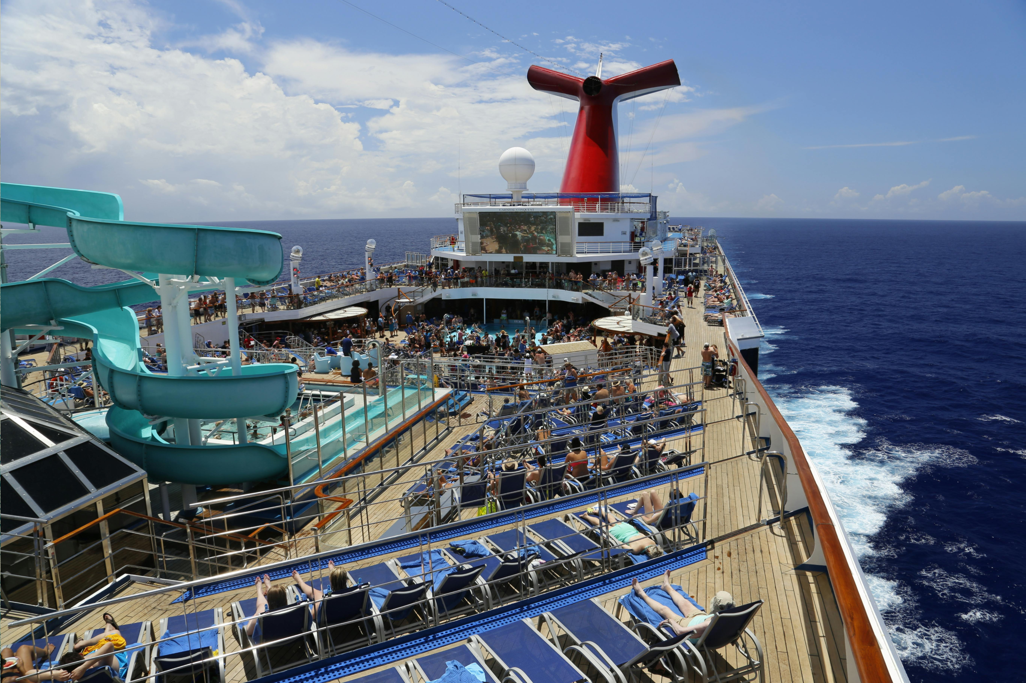 A busy but spacious cruise ship pool deck with multiple seating areas, illustrating how some cruise myths exaggerate how crowded ships actually feel.
