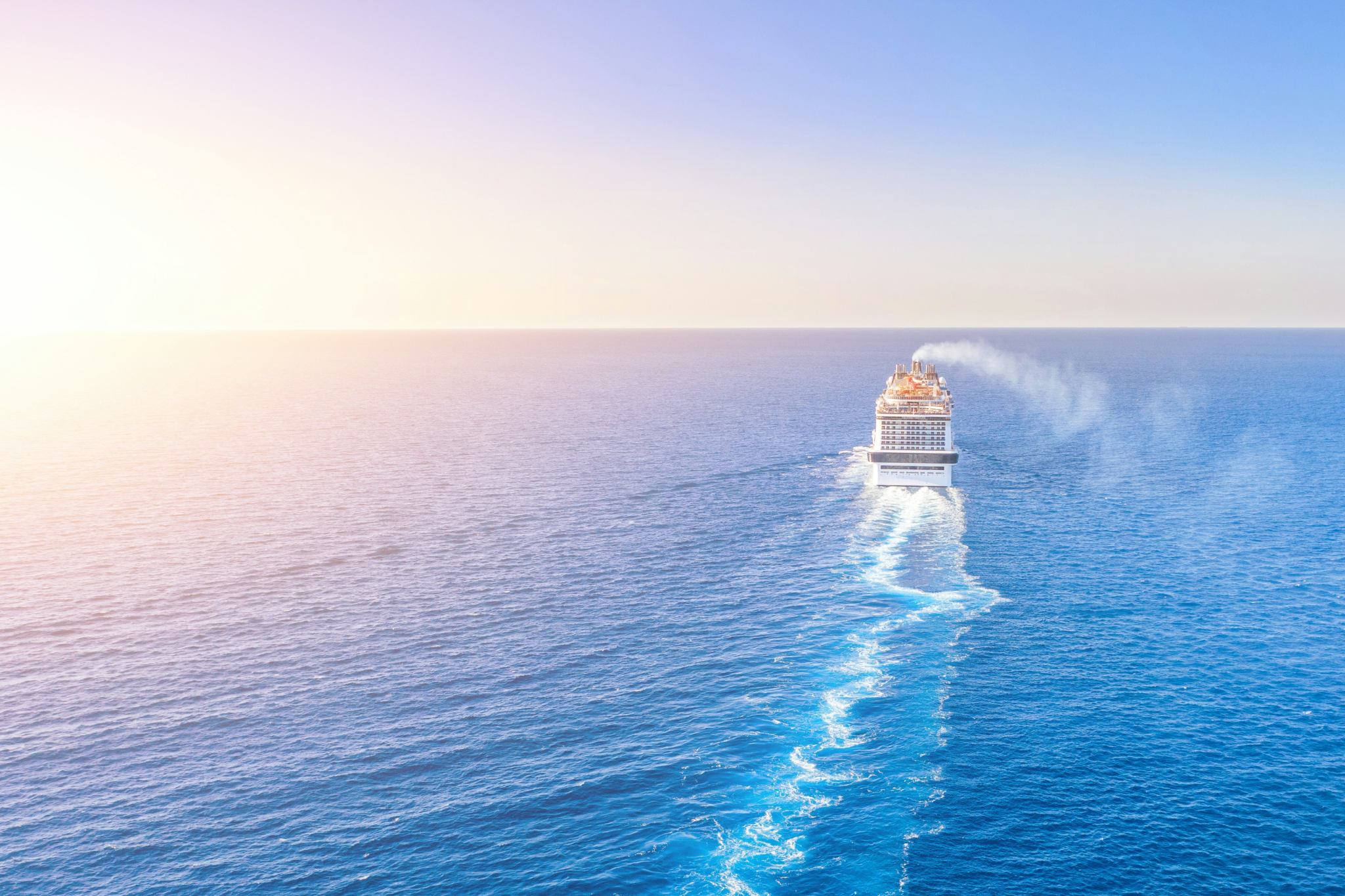 A cruise ship sailing across open ocean with wide sea views, challenging cruise myths that suggest passengers feel trapped or confined onboard.