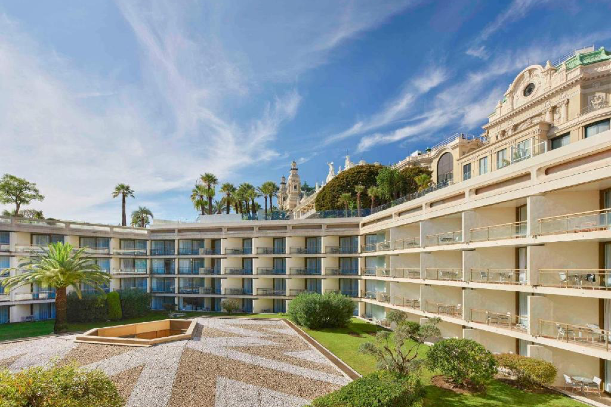 Interior courtyard of Fairmont Monte Carlo featuring modern architecture and views of the Monte Carlo Casino