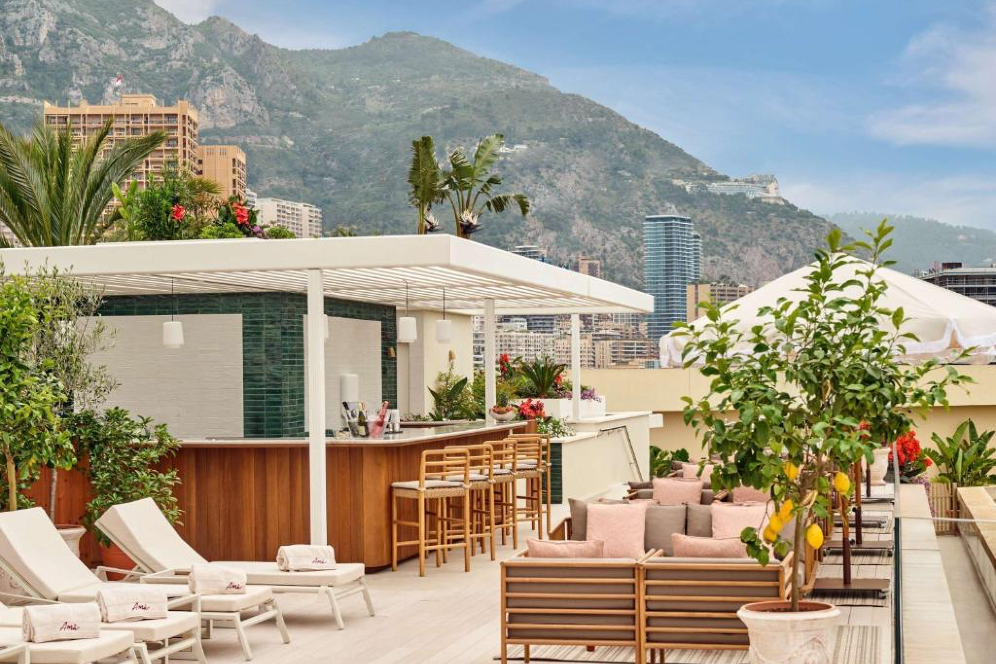 Rooftop bar and lounge at Fairmont Monte Carlo with mountain views and lush Mediterranean greenery