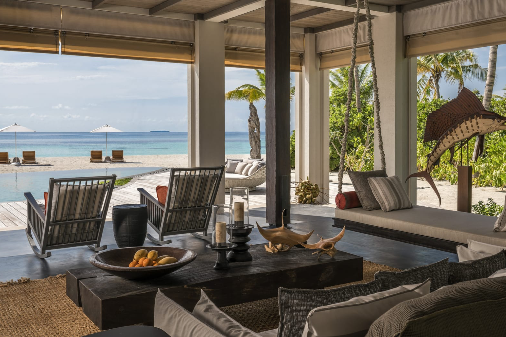 Open-air living space in a beachfront villa at Voavah, with ocean views, wooden décor, and tropical accents.