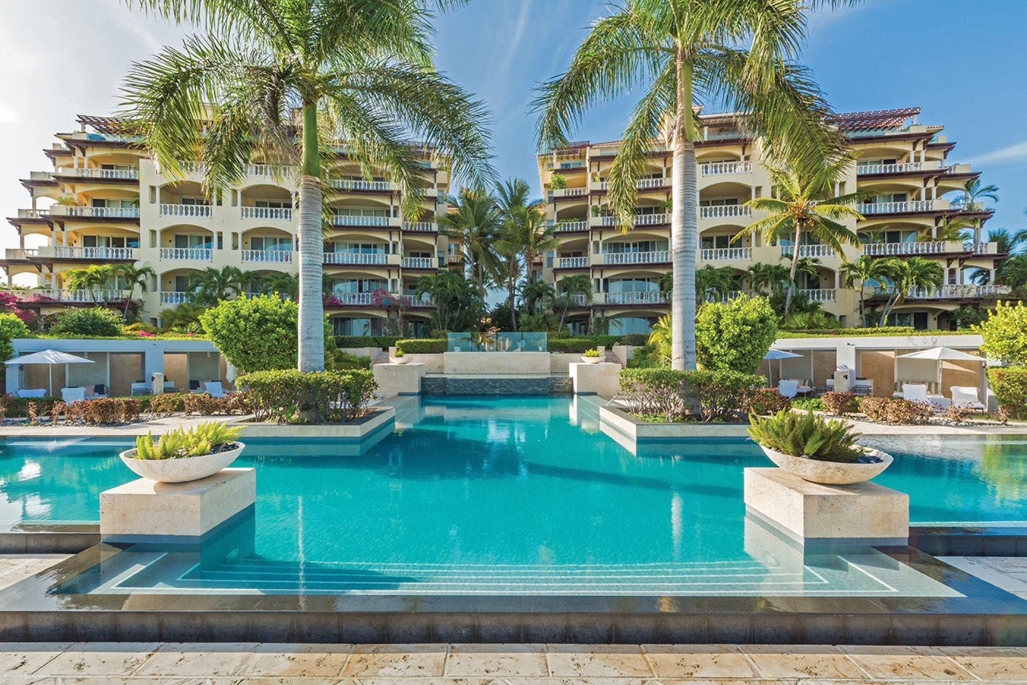 Central pool at Grace Bay Club with landscaped gardens and resort residences in the background.