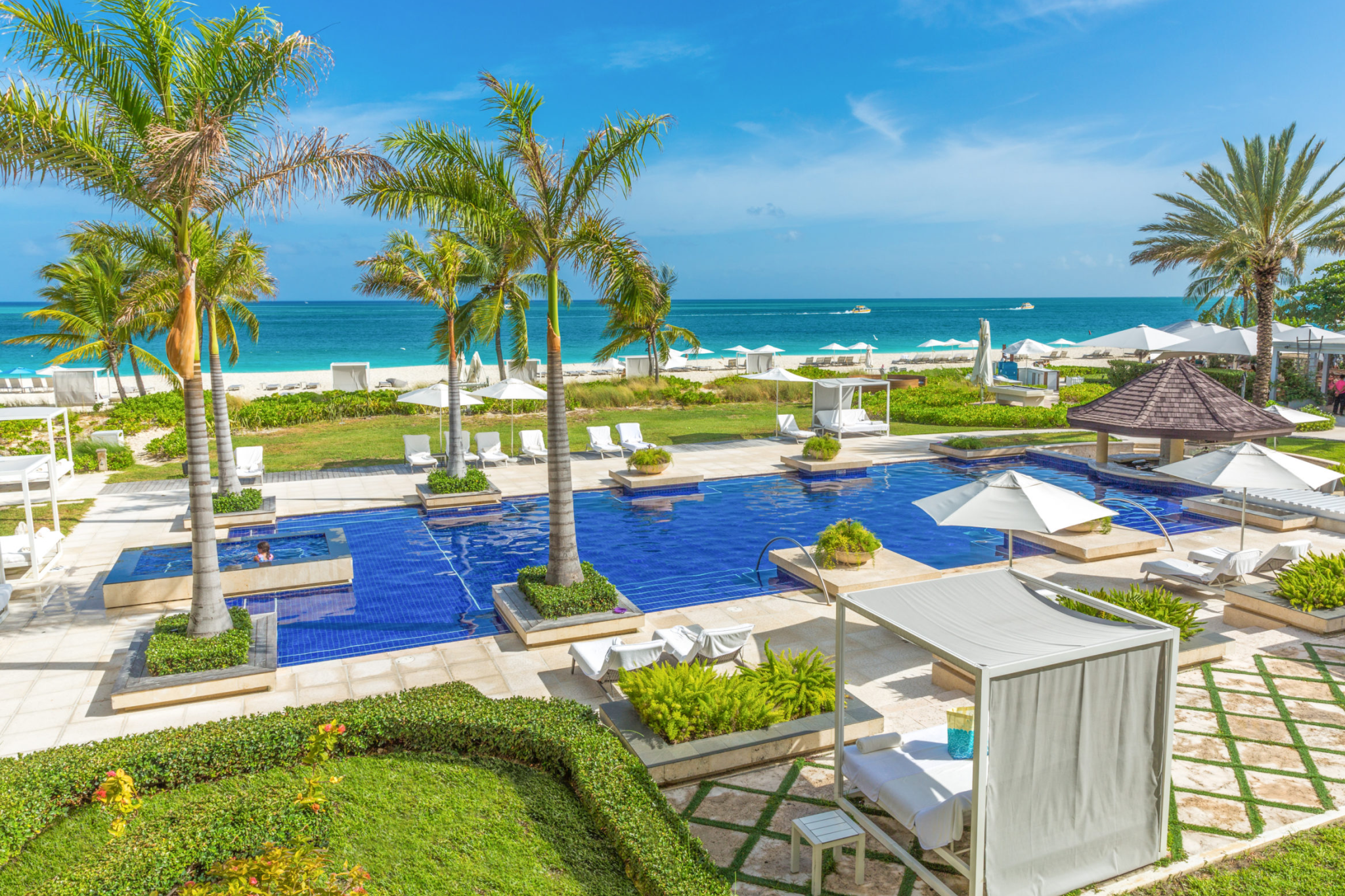 Grace Bay Club beachfront infinity pool overlooking turquoise waters and white sand beach.