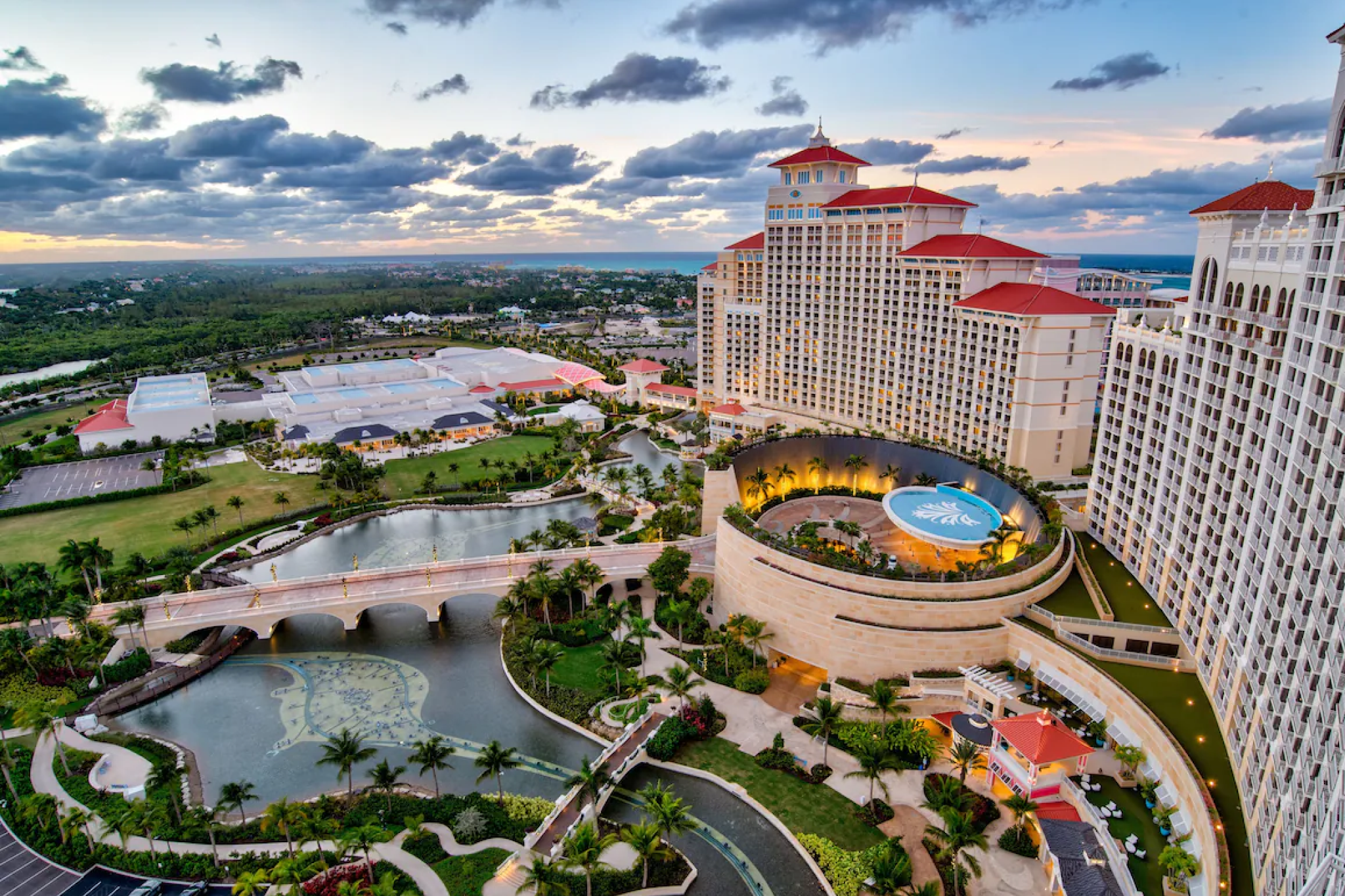 Aerial view of Grand Hyatt Baha Mar resort with pools, bridges, and lush landscaping at sunset in Nassau, Bahamas