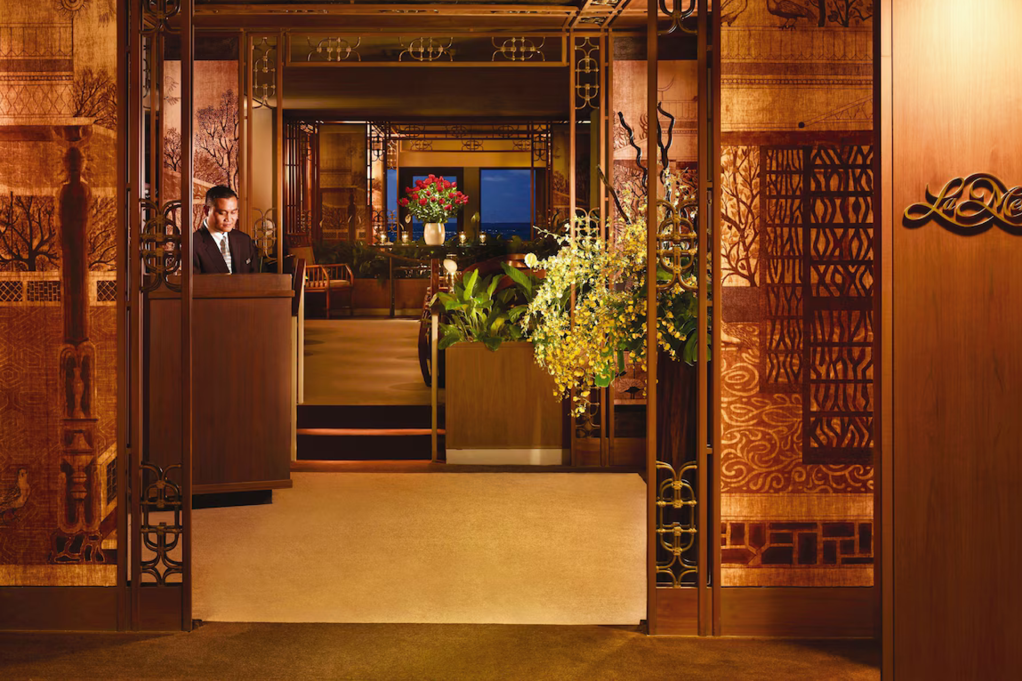 Elegant entrance to La Mer, the fine-dining restaurant at Halekulani Hotel, showcasing refined decor and welcoming service.