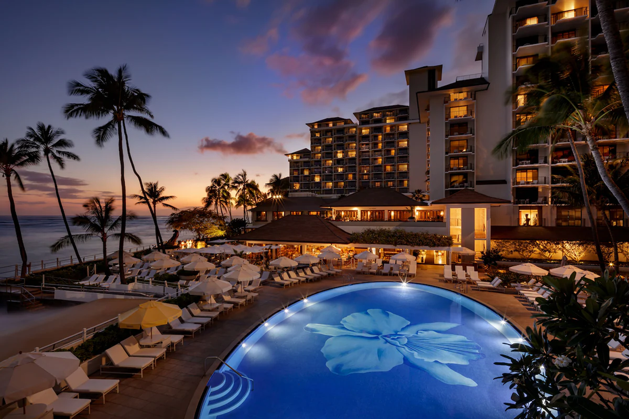 Oceanfront pool at Halekulani Hotel in Waikiki at sunset, featuring the signature orchid mosaic design and tranquil Pacific views.