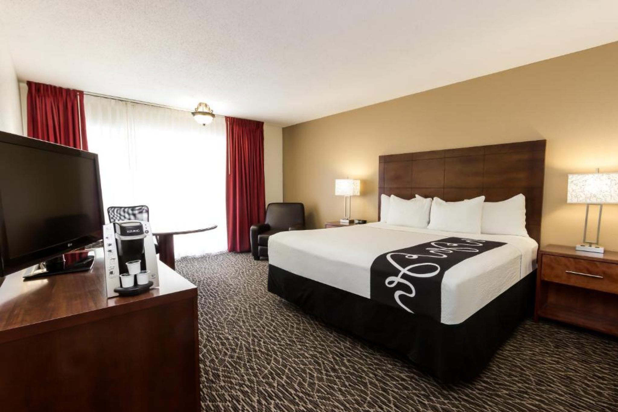 Spacious king room at la quinta inn by wyndham clearwater central, featuring a modern design, Keurig coffee maker, and work desk.