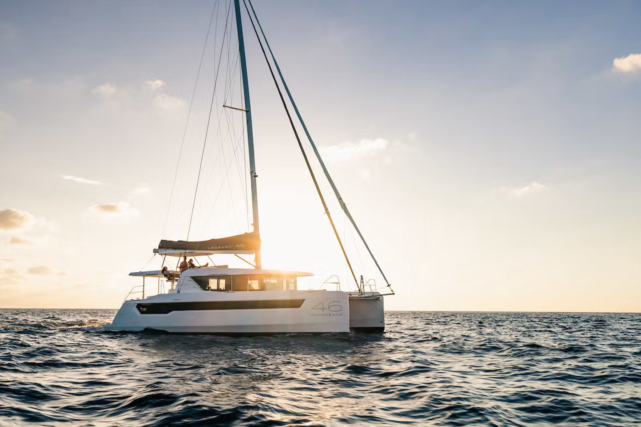 Side profile of the Leopard 46 catamaran at anchor, illustrating its design lines, cockpit layout, and helm position in daylight