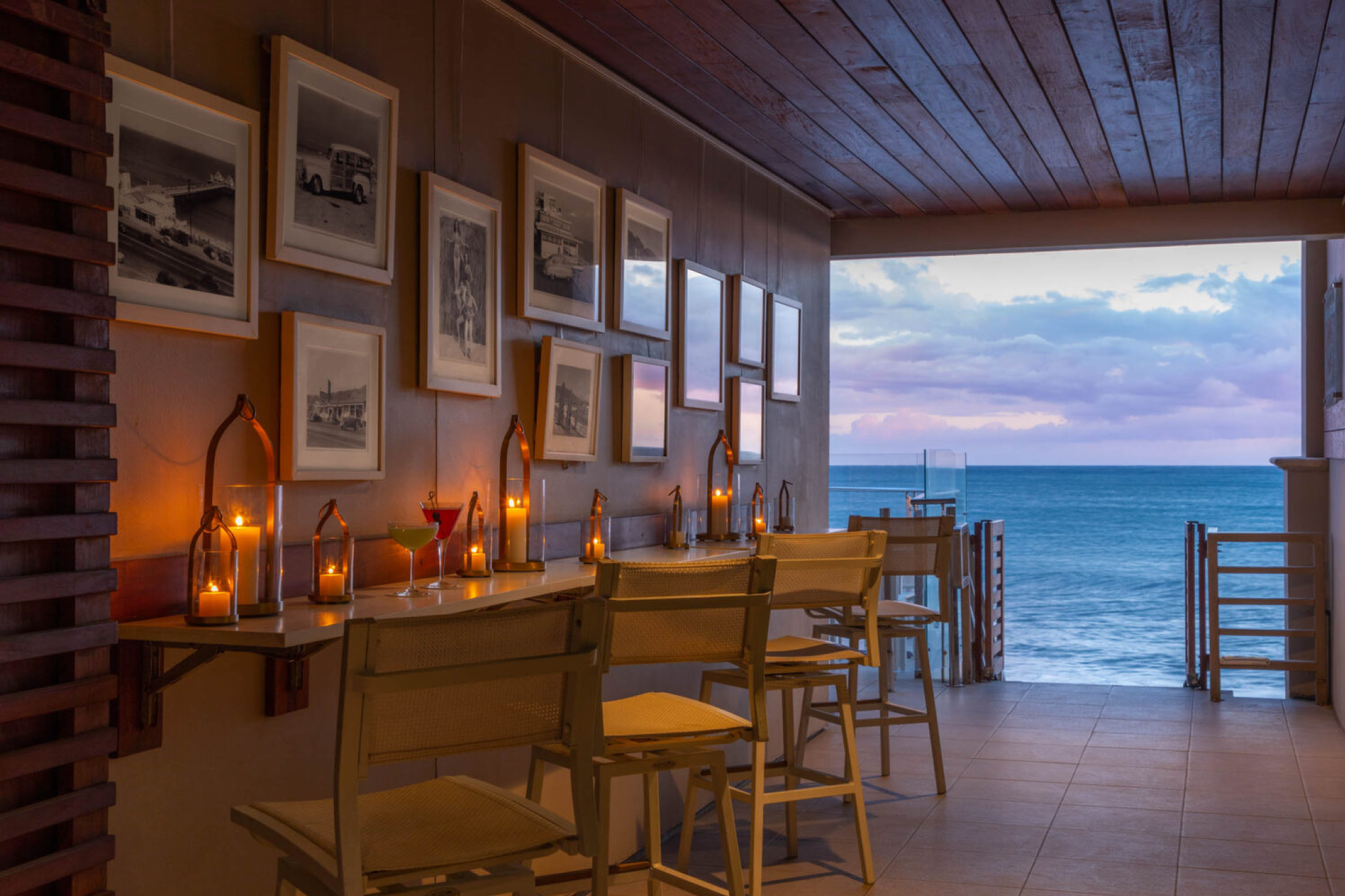 Candlelit bar seating at Malibu Beach Inn with ocean view at sunset