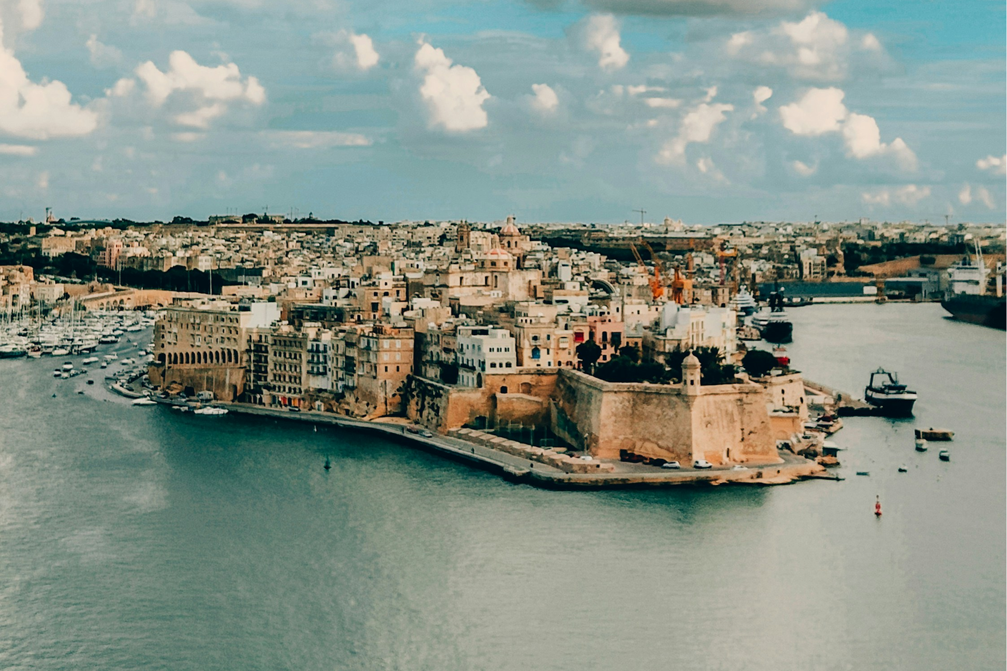 Mediterranean port city visited by MSC Magnifica, showing historic architecture and a scenic waterfront with boats.