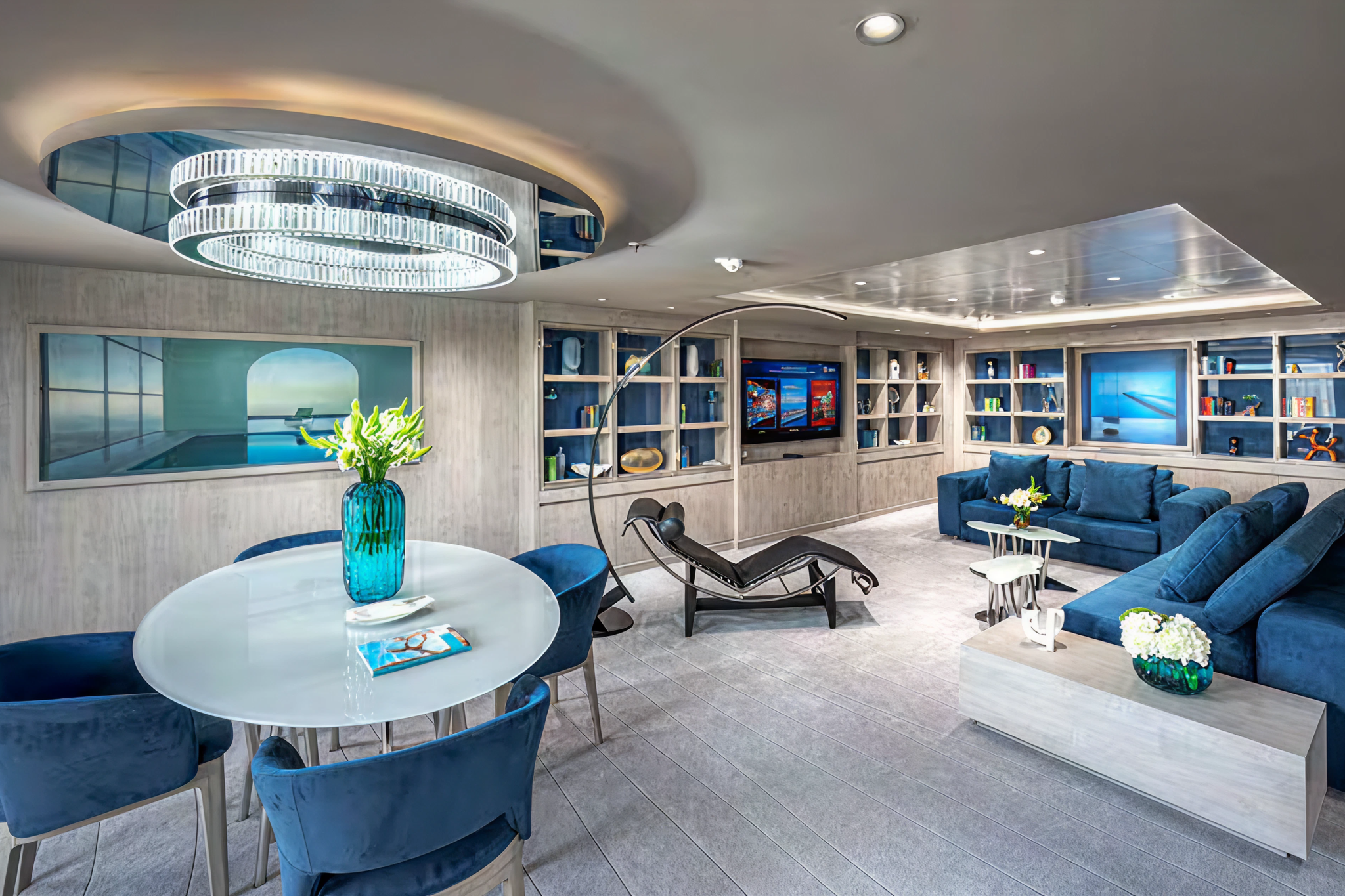 Exclusive Yacht Club lounge aboard MSC World America, designed with plush seating, entertainment center, and modern art.