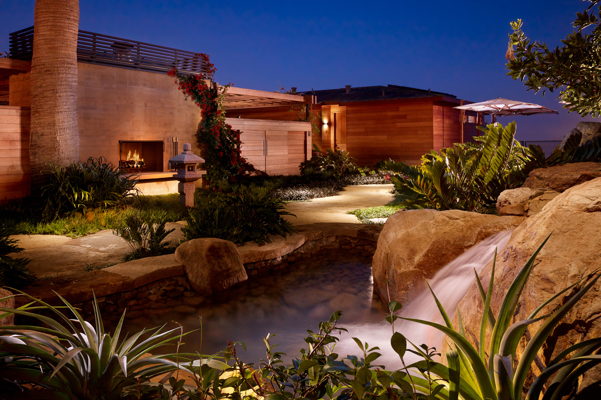 Garden view at Nobu Ryokan Malibu with outdoor fireplace and tranquil landscaping at night