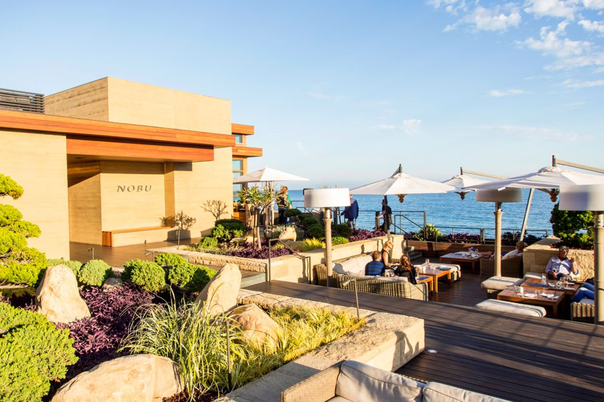 Outdoor dining terrace at Nobu Ryokan Malibu with Pacific Ocean backdrop