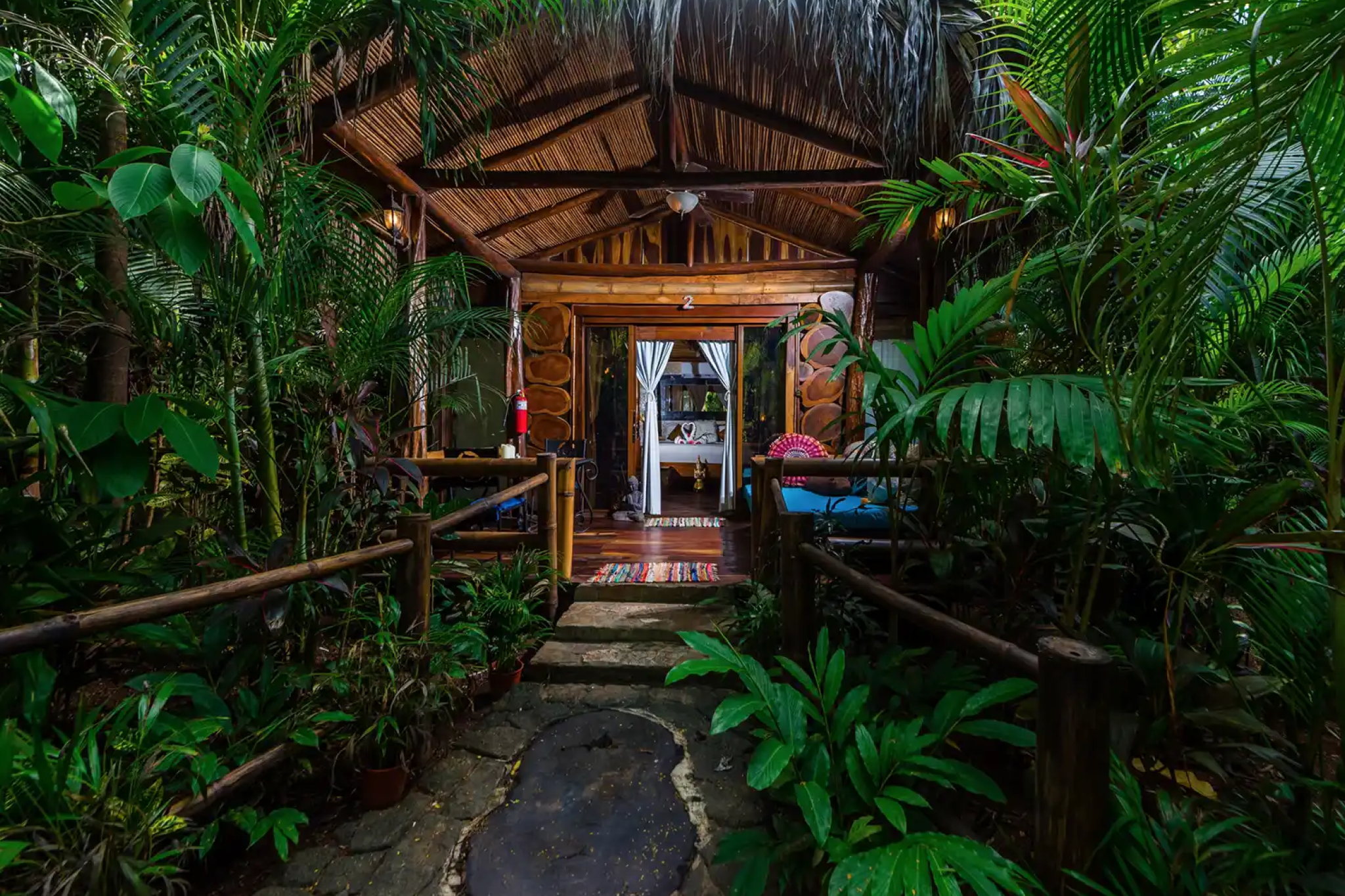 Interior of a luxury bungalow at Ocho Artisan Bungalows with wooden finishes, open-air design, and private patio seating.