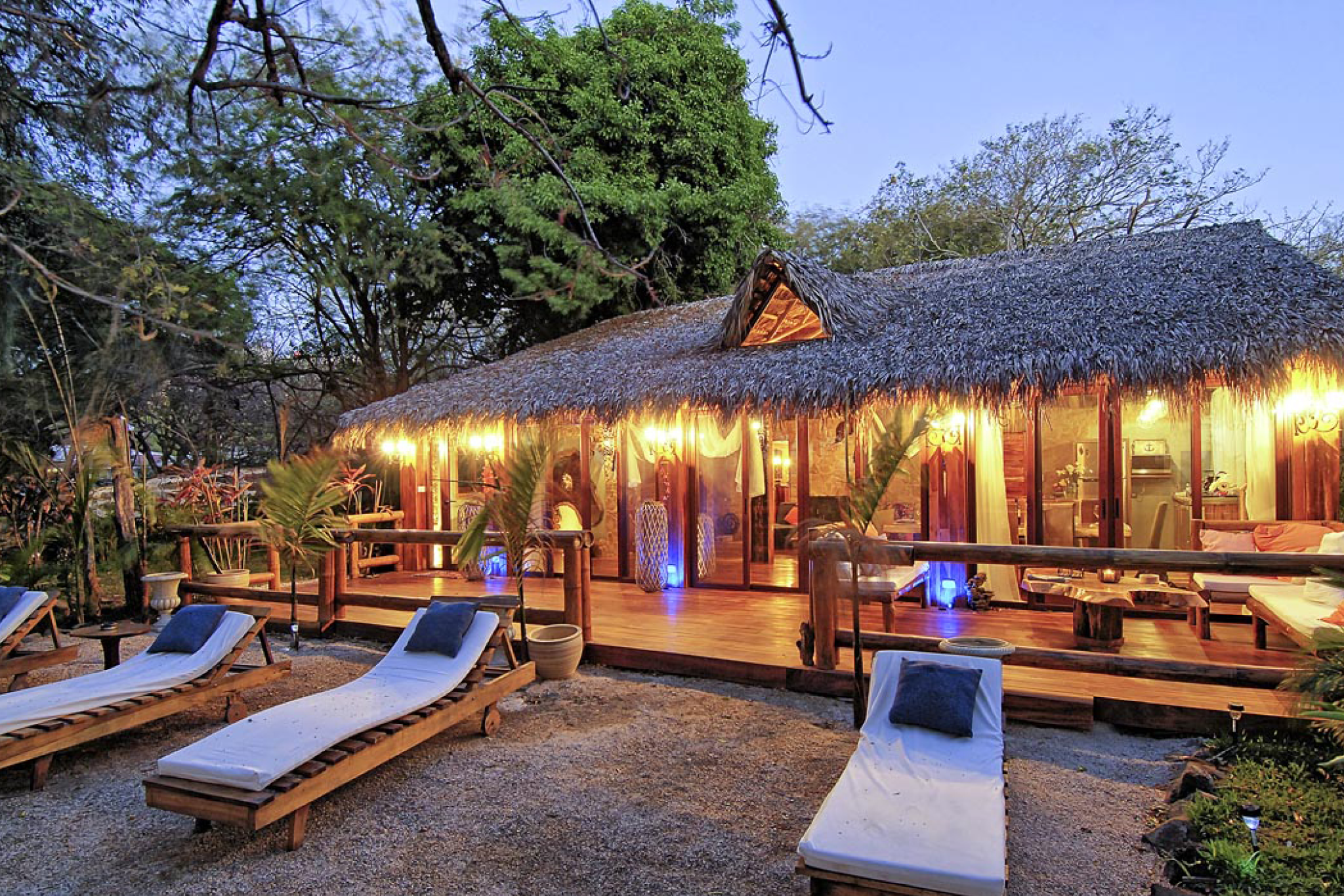 Aerial view of Ocho Artisan Bungalows in Tamarindo, Costa Rica, with sandy beach, tropical trees, and blue ocean waters.