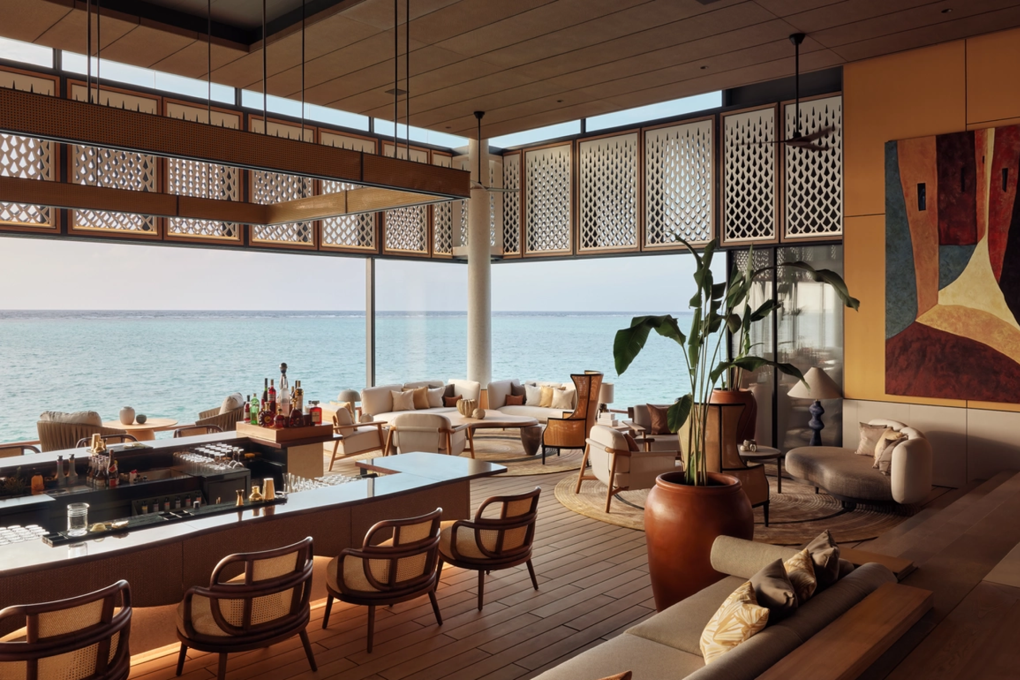 Lounge and bar area at One&Only Reethi Rah with wood-accented interiors and panoramic views of the Indian Ocean.