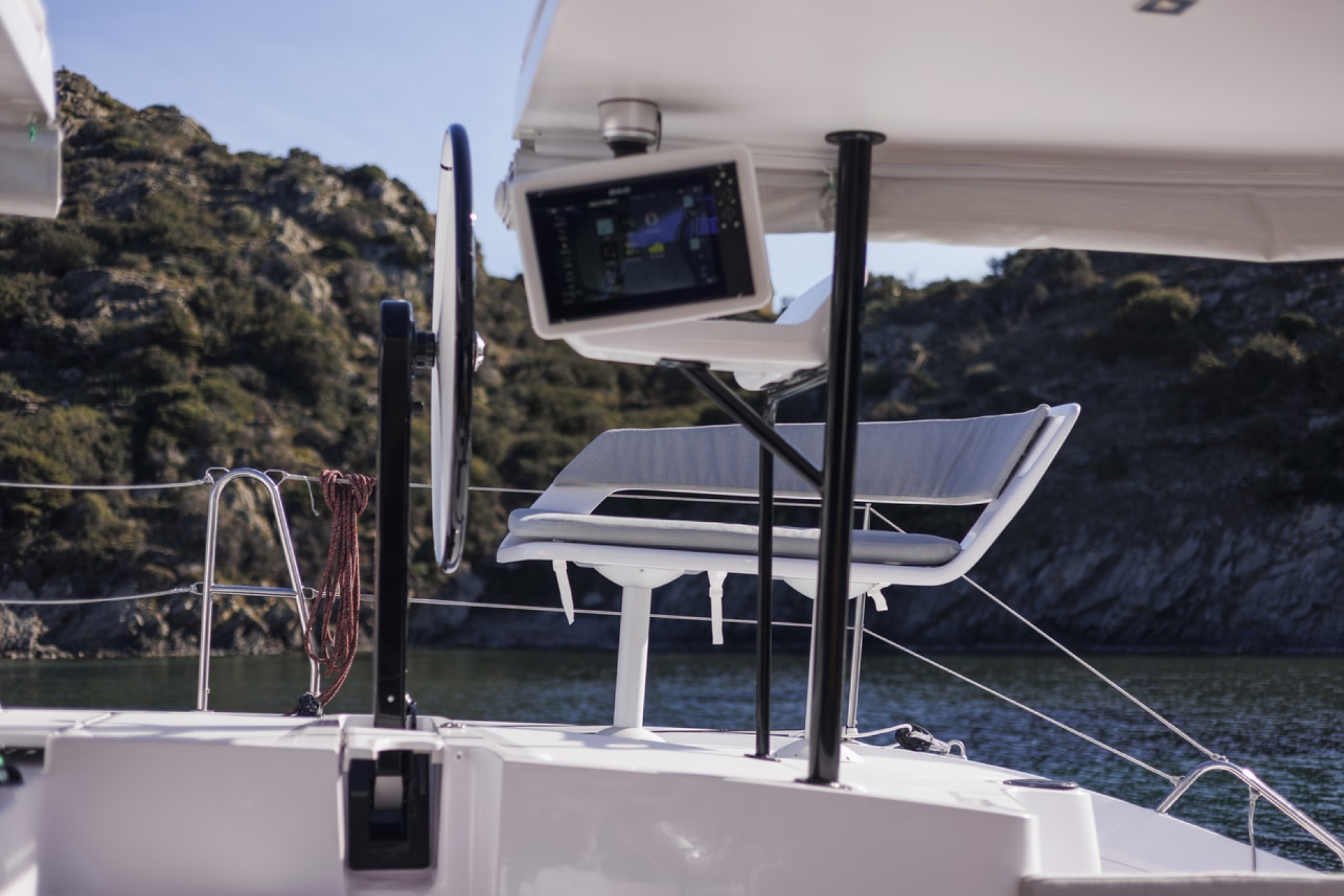 Outremer 52 helm station with wheel, navigation screen, and raised seating position.