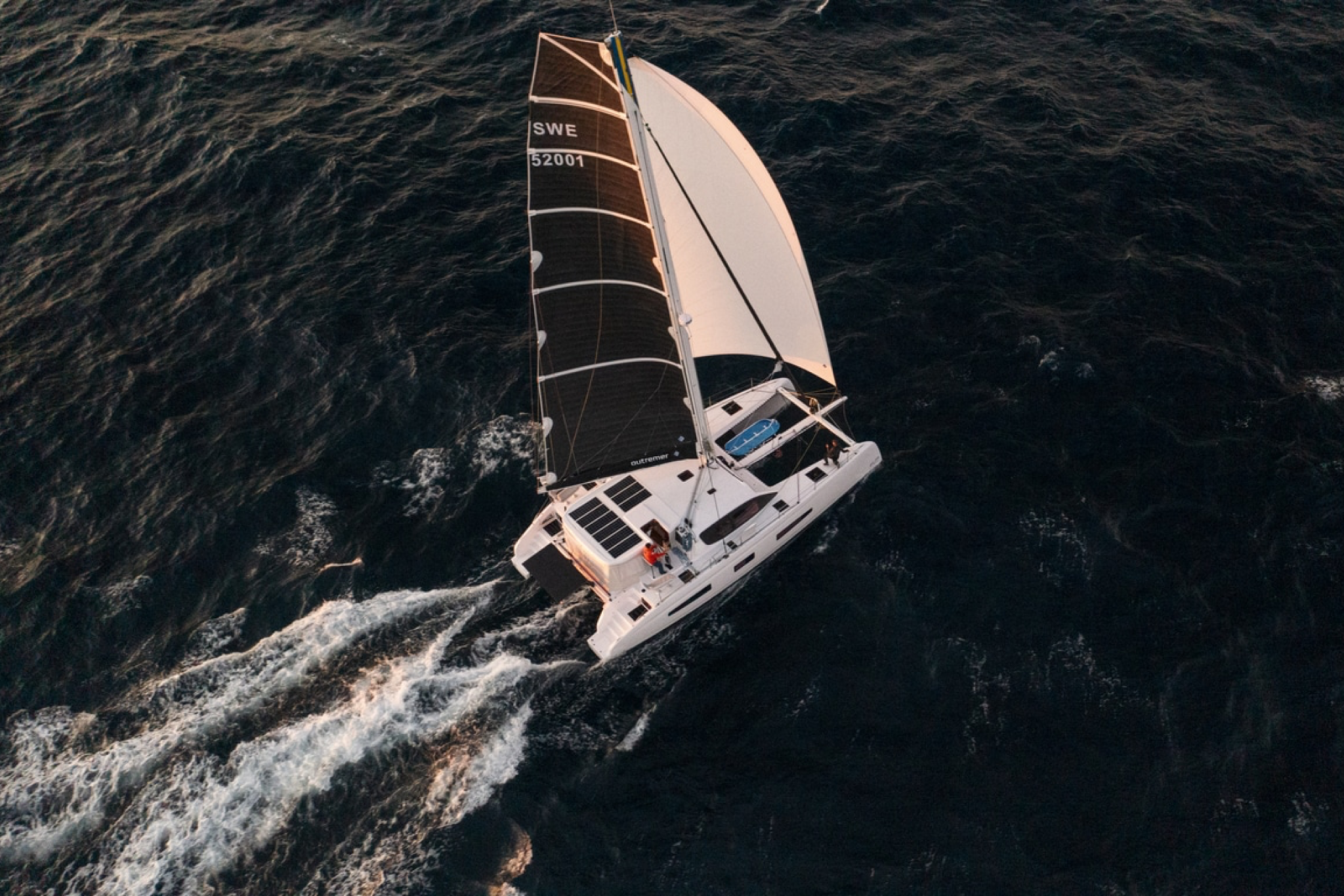 Aerial view of the Outremer 52 sailing catamaran under full sail at sea.