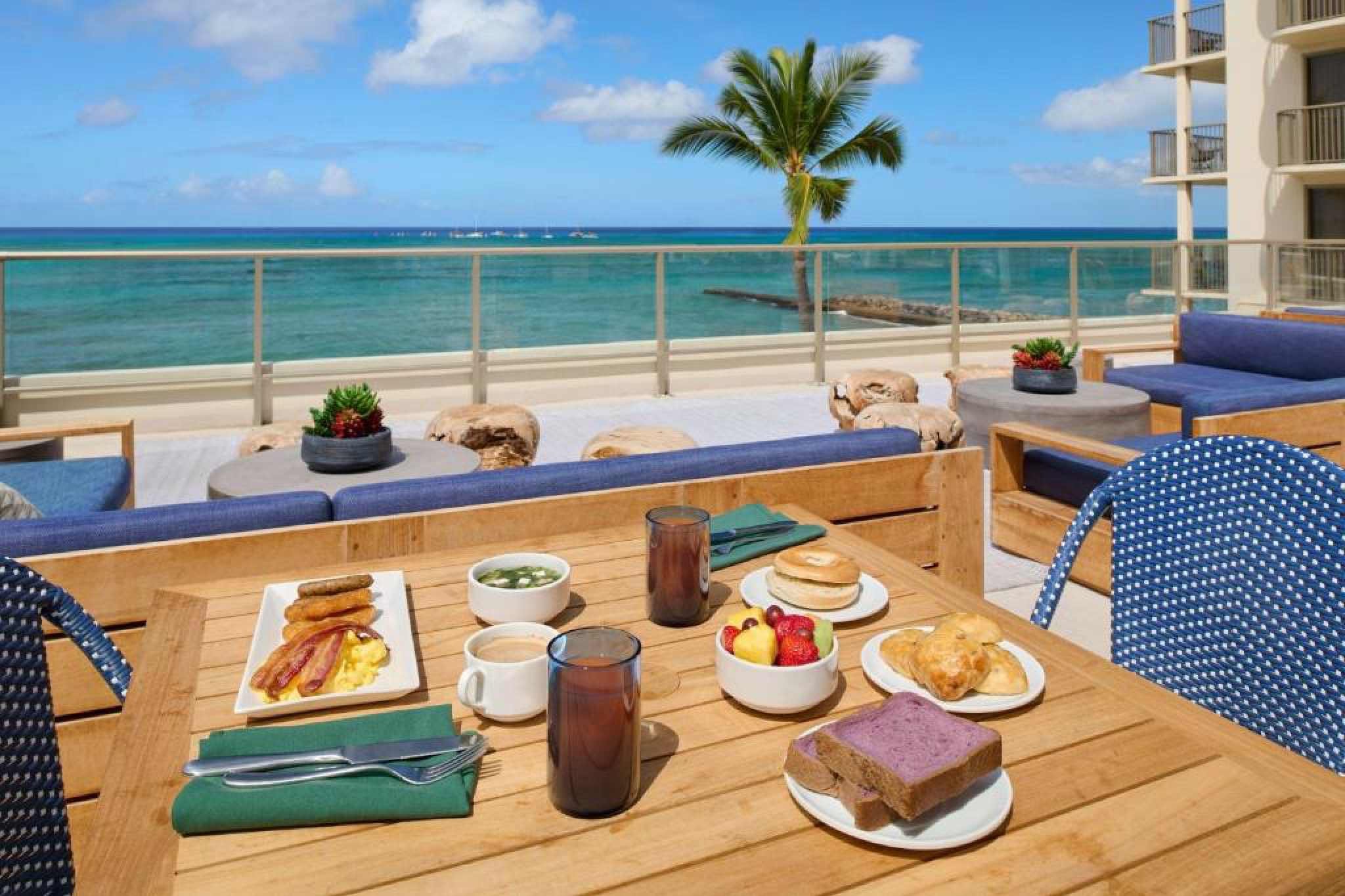 Oceanview breakfast setup at Outrigger Reef Waikiki Beach Resort’s Voyager 47 Club Lounge, with Hawaiian and continental breakfast dishes overlooking the beach.