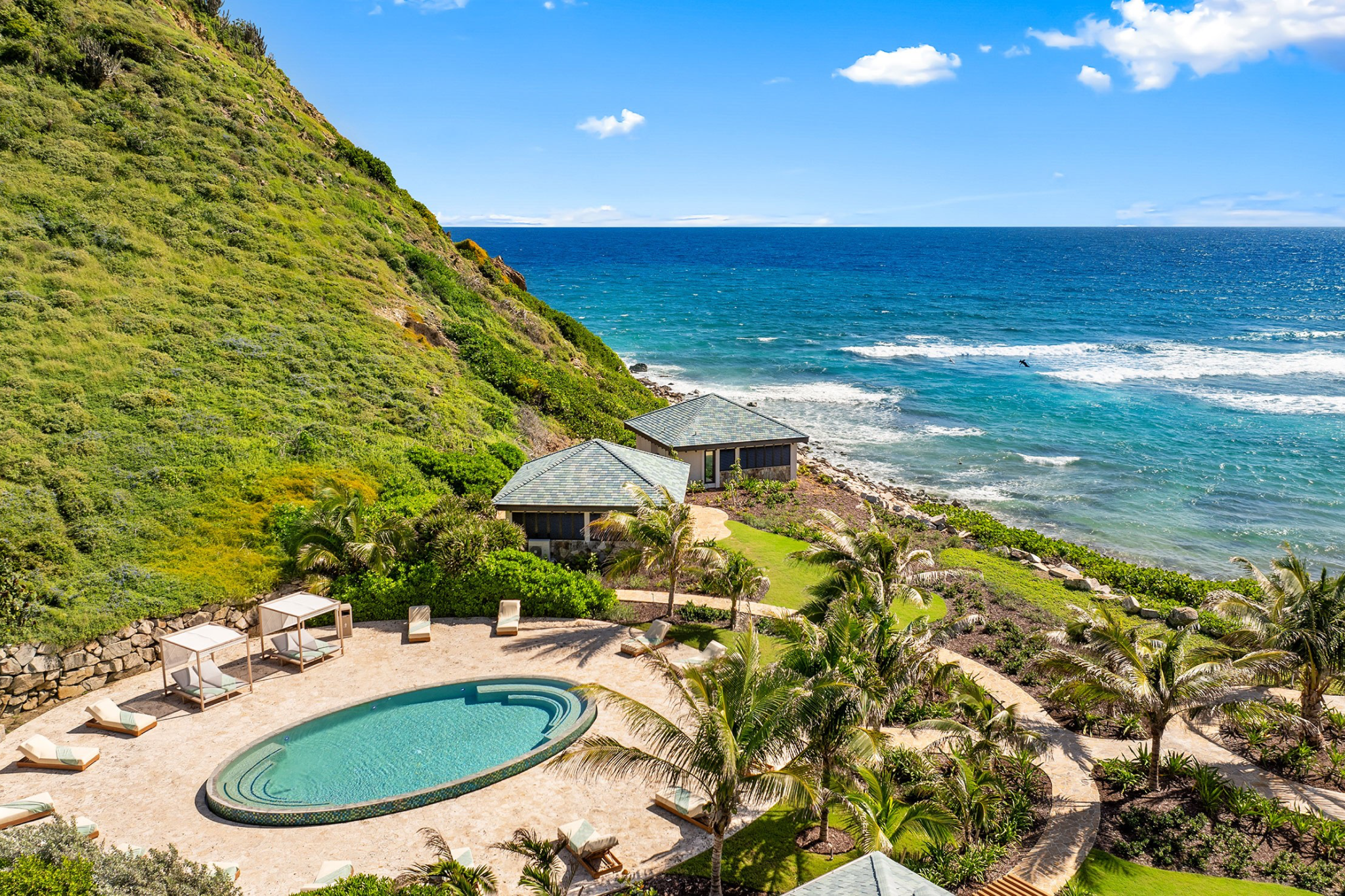 Oceanfront pool and villas at Peter Island Resort overlooking the Caribbean Sea, highlighting outdoor relaxation and island experiences.