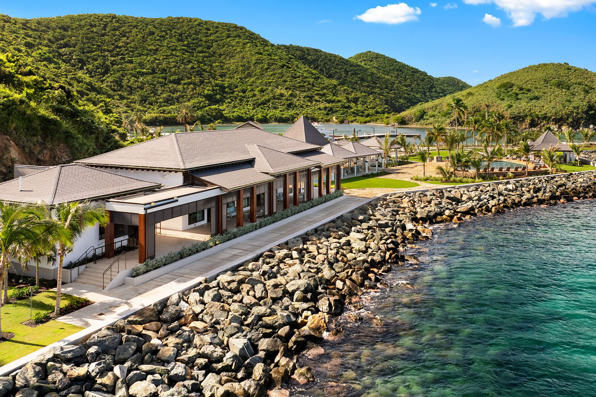 Aerial view of Peter Island Resort in the British Virgin Islands, showing beachfront villas and lush green hills surrounding the private island retreat.