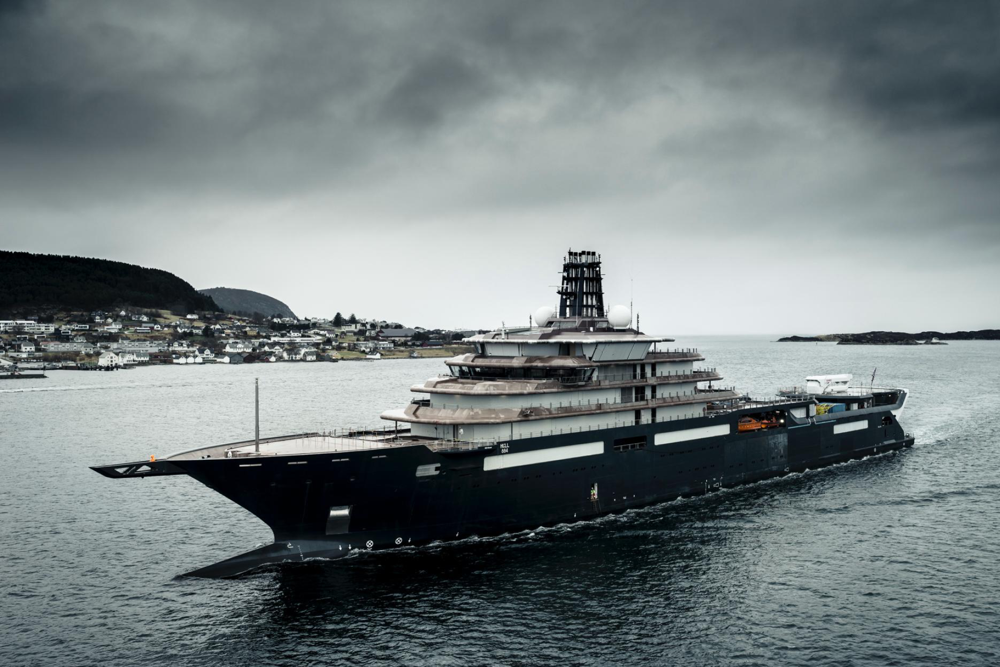 Side profile of the REV Ocean superyacht revealing its extraordinary length, tiered decks, helipad facilities, and integrated research zones, highlighting the vessel’s scale, endurance, and expedition-ready architecture.