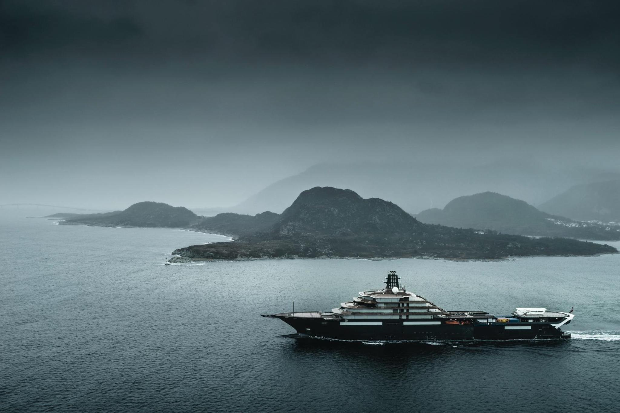 REV Ocean superyacht cruising near rugged Norwegian coastline during sea trials, illustrating its operational readiness, long-range expedition design, and anticipated late-2026 launch timeline.