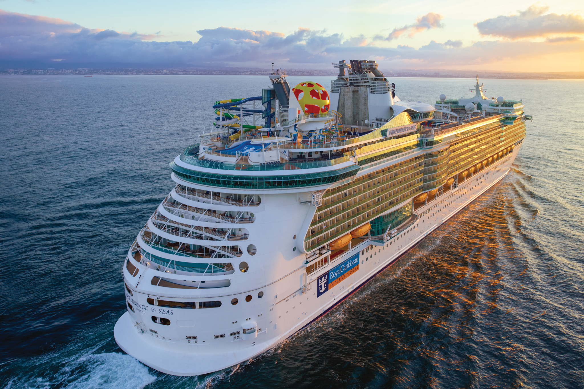 Royal Caribbean Ships by Size ranking featuring Independence of the Seas at sunset, emphasizing its Freedom Class scale, aft design, and illuminated decks
