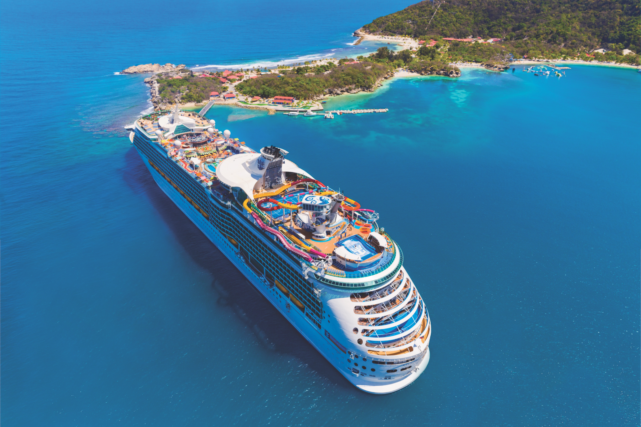 Royal Caribbean Ships by Size comparison featuring Navigator of the Seas near a tropical island, highlighting its Voyager Class design and modernized top deck