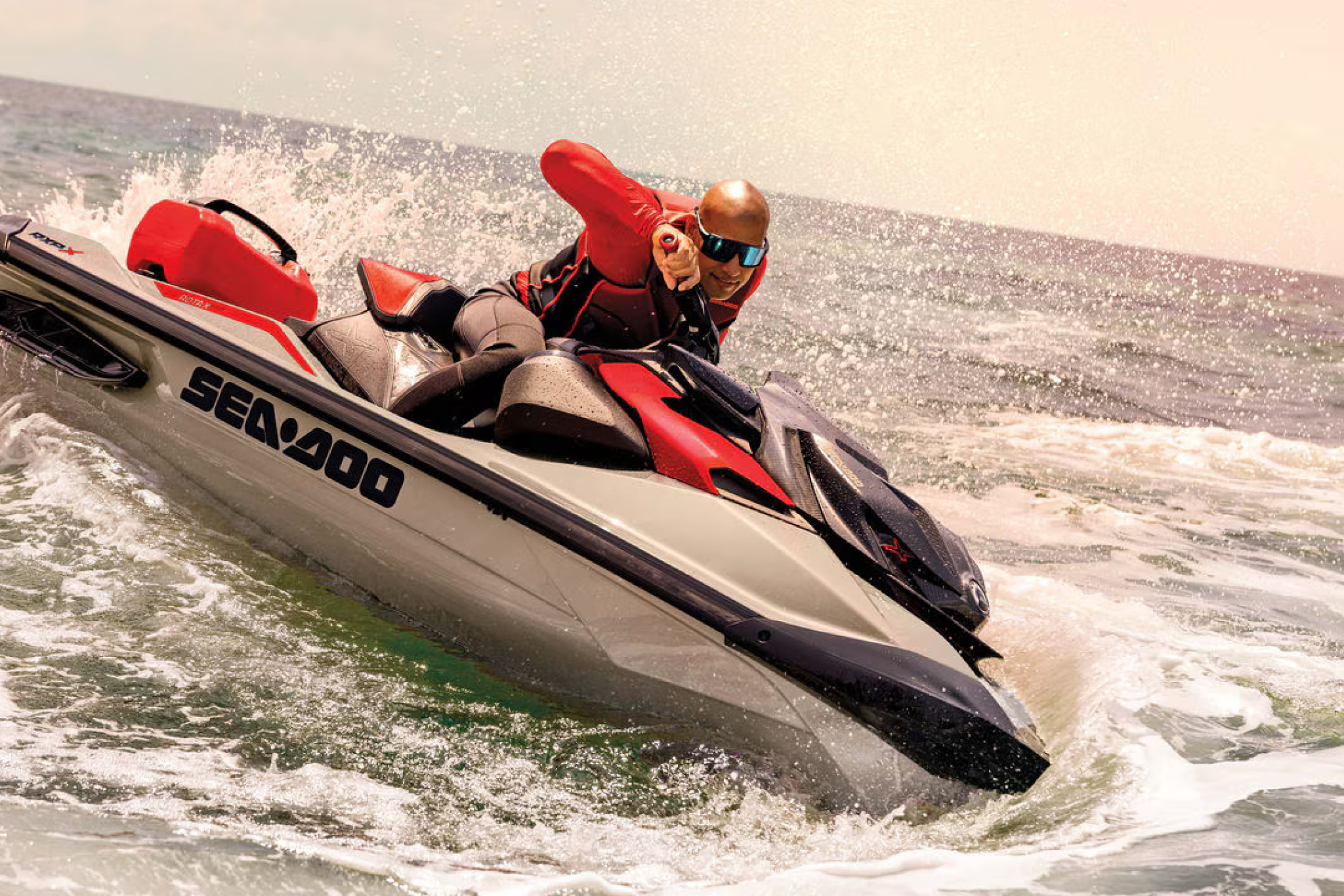 Close-up view of a rider leaning into a turn on the RXP-X 325, showing the Ergolock-R seat, footwell wedges, and body positioning during aggressive maneuvers