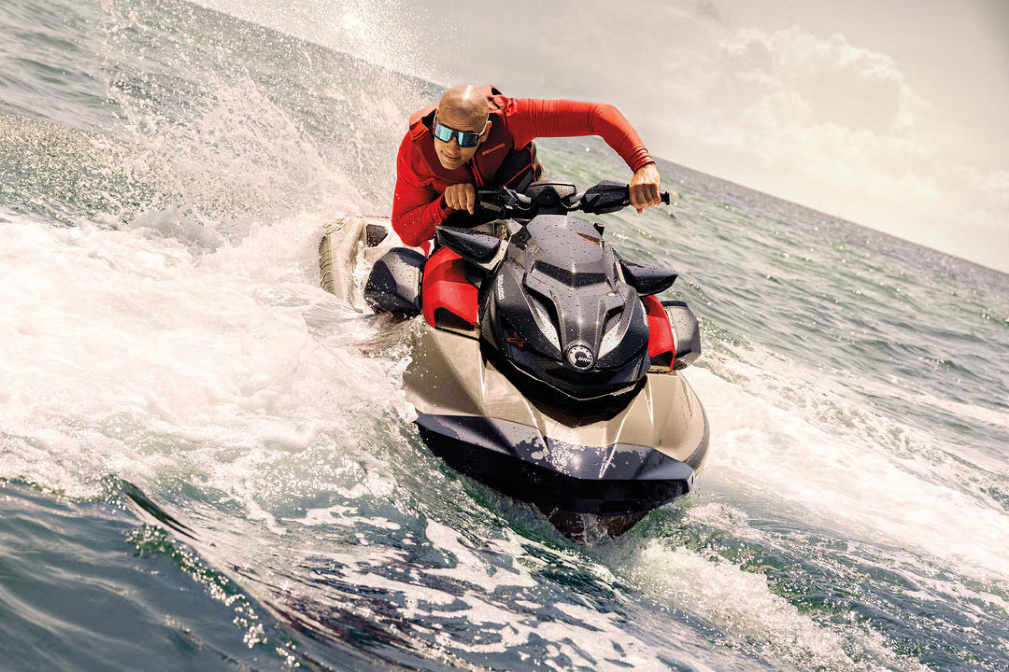 The Sea-Doo RXP-X 325 in action on the water, showing its aggressive hull design, bold red-and-black color scheme, and rider in a low racing stance