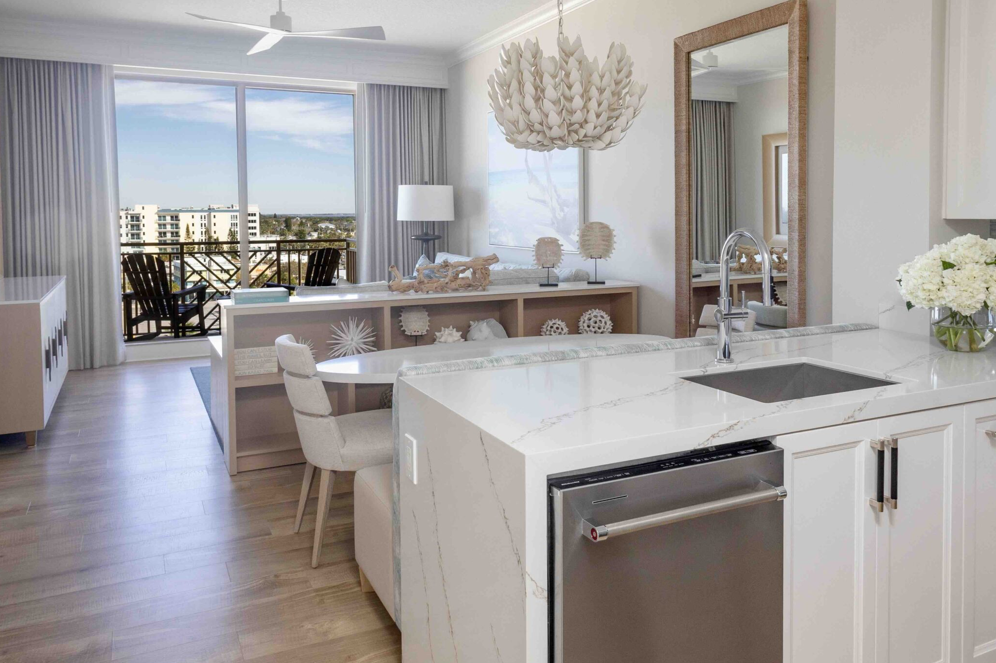 Modern suite at Sandpearl Resort showcasing a marble kitchen, elegant coastal décor, and a private balcony overlooking Clearwater Beach.