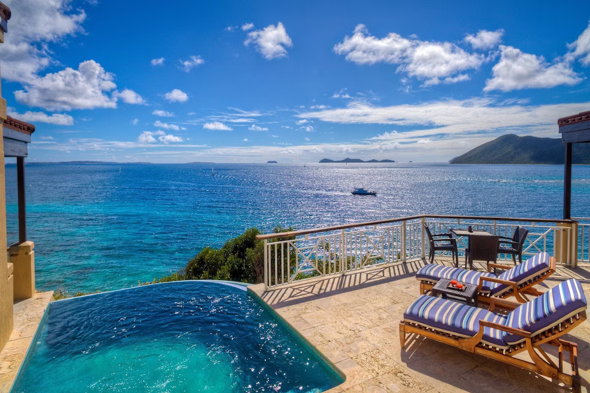 Private plunge pool and sun loungers overlooking the turquoise Caribbean Sea at Scrub Island Resort Spa & Marina, with sailboats visible in the distance.