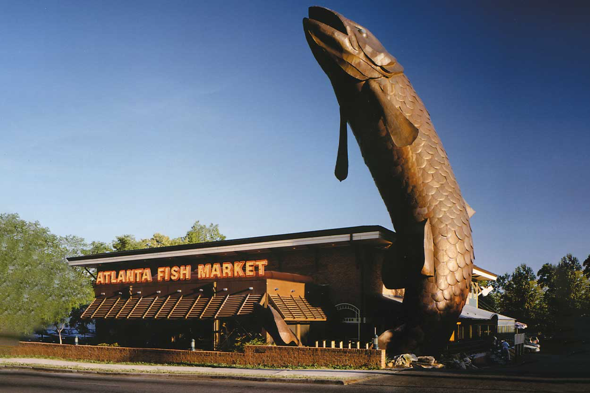 Iconic fish sculpture and bustling interior of Atlanta Fish Market, a go-to spot on the list of best seafood restaurants in Atlanta, Georgia.