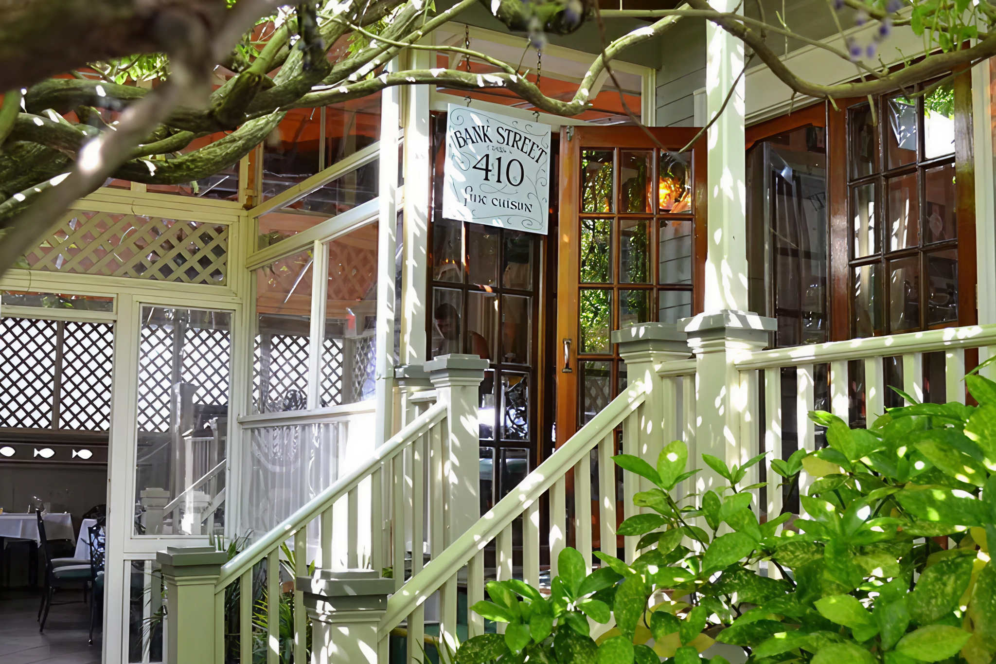 Leaf-shaded entrance of 410 Bank Street Restaurant in a restored Victorian home, offering French-Creole seafood that ranks it among the Best Seafood Restaurants in Cape May.