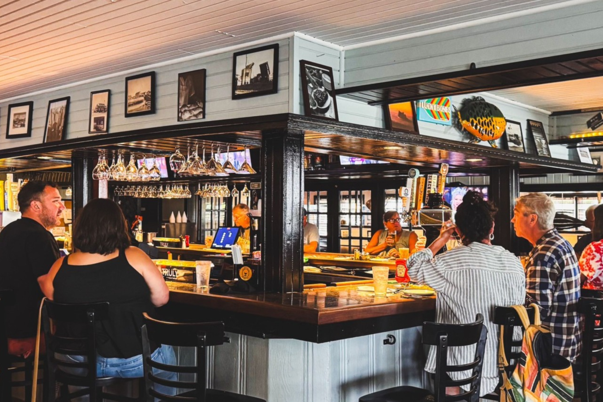 Cozy bar interior at Lucky Bones, featuring wood accents and local patrons enjoying seafood and drinks at one of the Best Seafood Restaurants in Cape May.