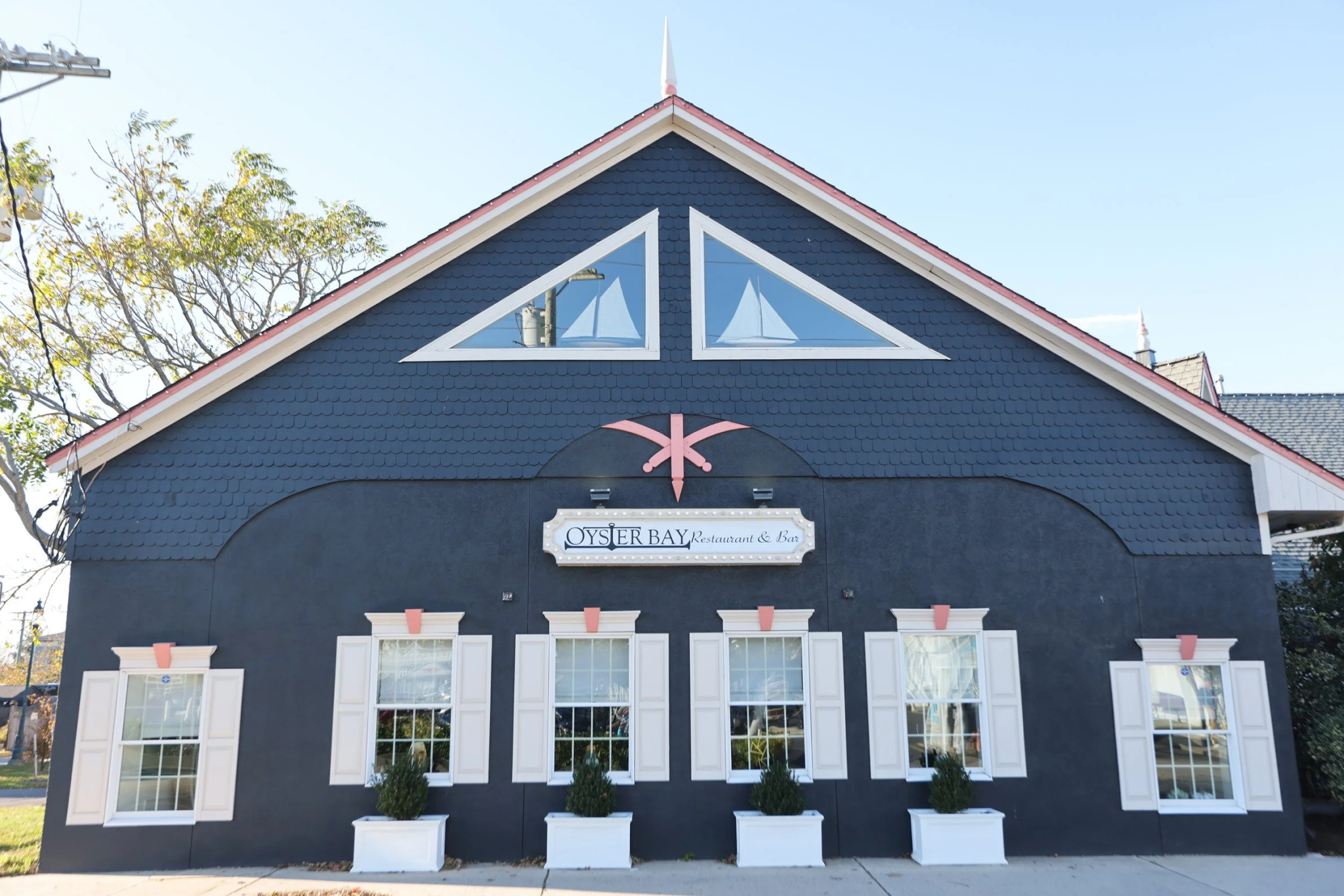 Front exterior of Oyster Bay Steak & Seafood with navy siding and white trim, representing the top spot on the Best Seafood Restaurants in Cape May list for surf-and-turf dining.