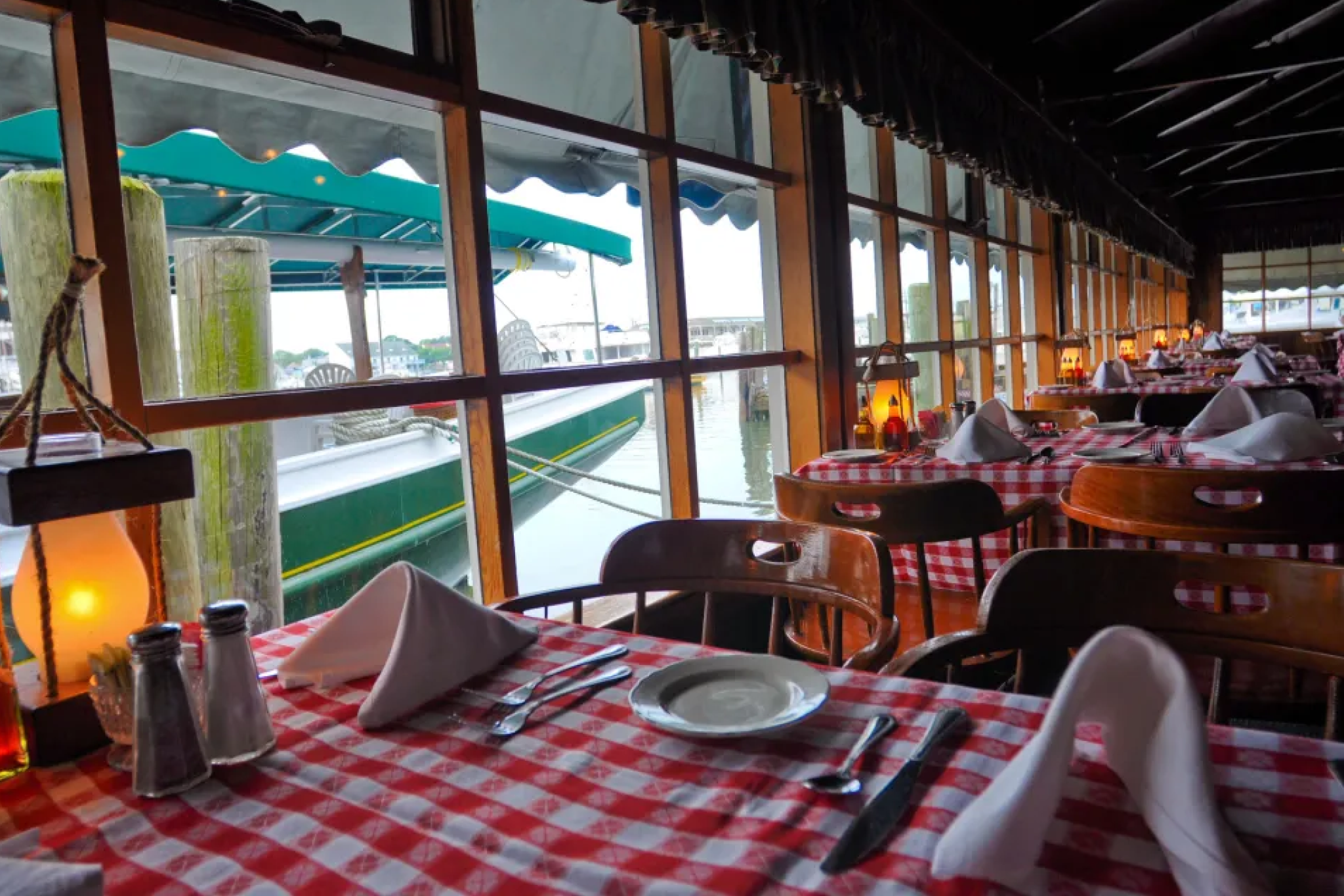 Nautical-themed interior with red-and-white checkered tables overlooking the marina at The Lobster House, a Cape May institution featured on the Best Seafood Restaurants in Cape May list.