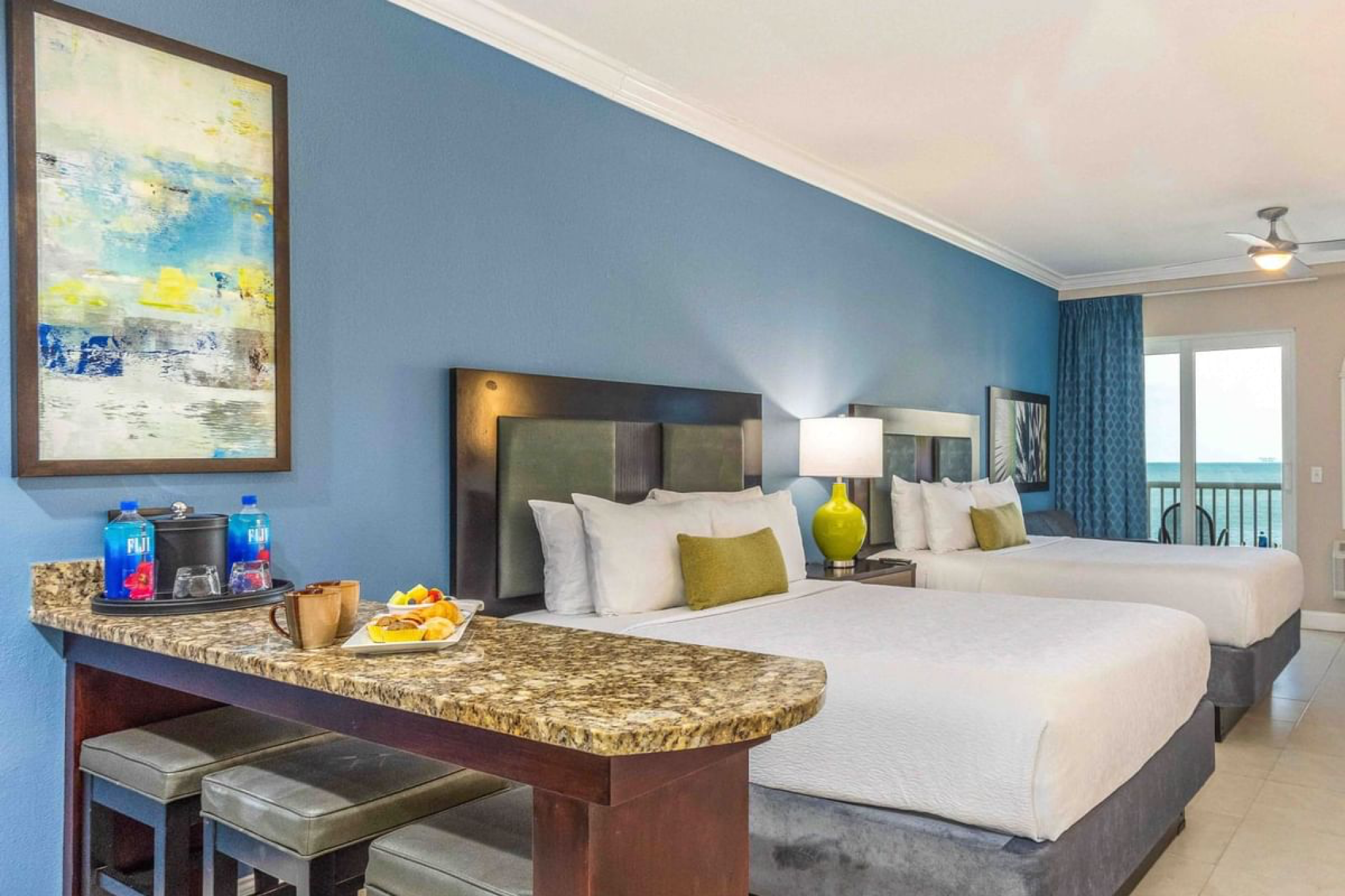 Oceanview guest room at Shephard’s Beach Resort Clearwater featuring two queen beds, a breakfast bar, and modern coastal decor.