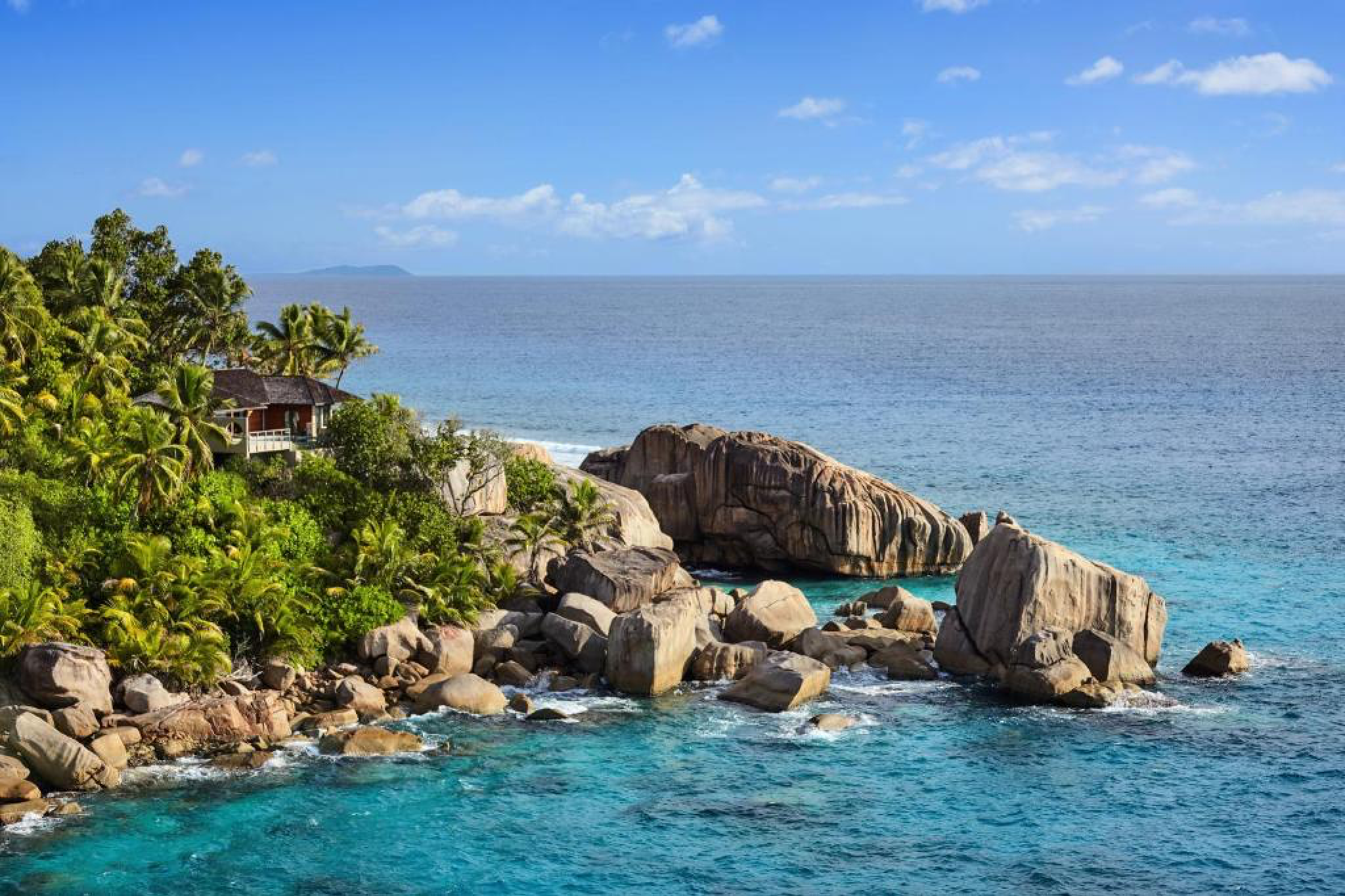 Secluded coastline of Félicité Island, where Six Senses Zil Pasyon is located, with dramatic granite rock formations and turquoise water.