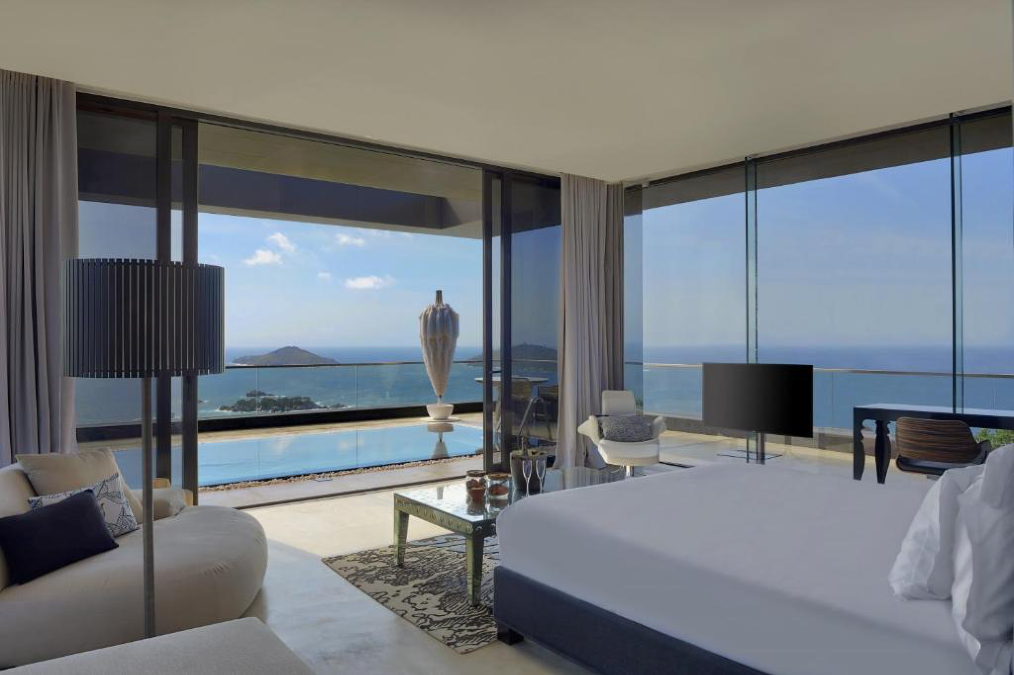 Interior of an ocean-view villa bedroom at Six Senses Zil Pasyon with floor-to-ceiling windows, infinity pool, and sweeping island views.