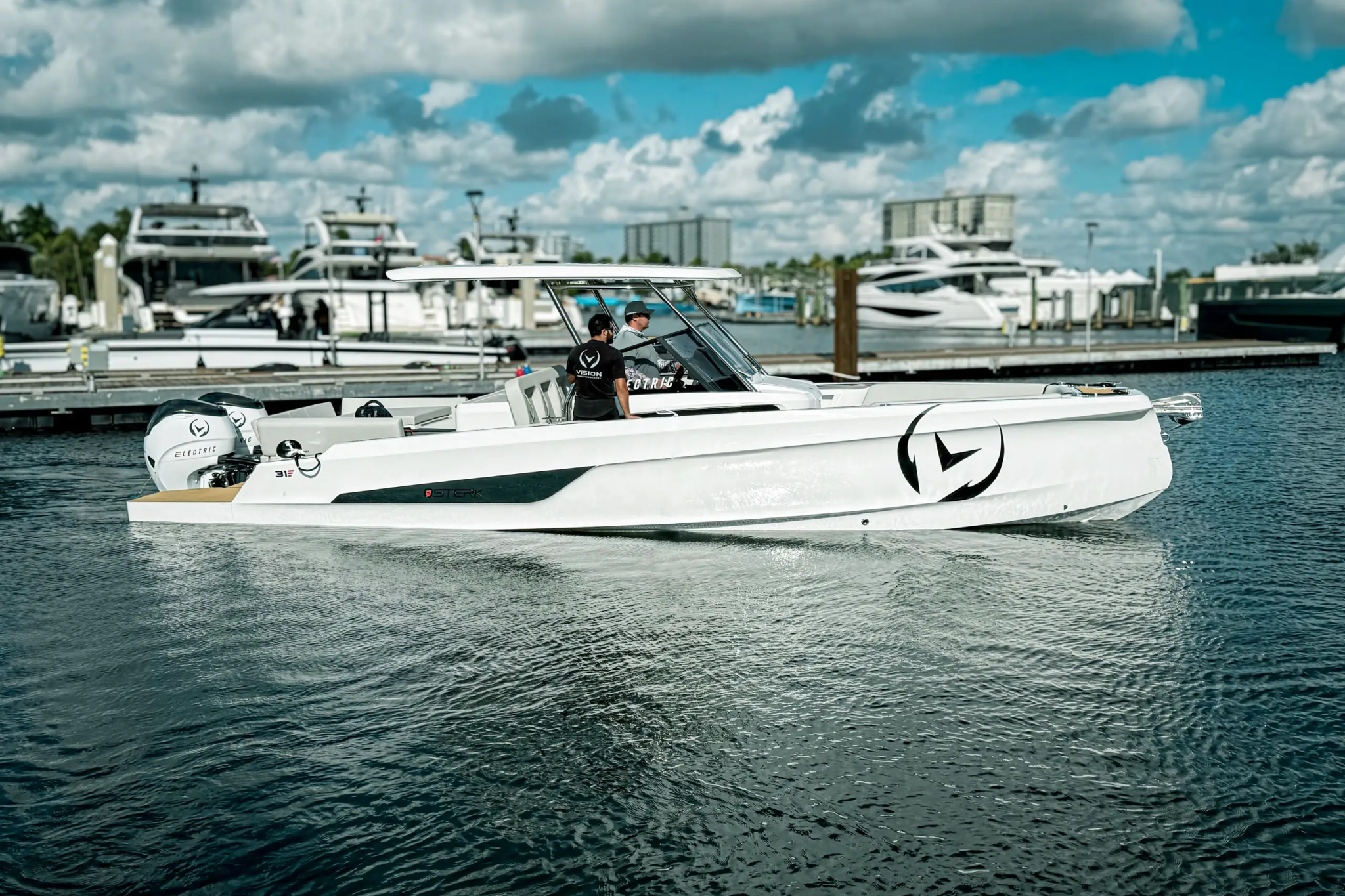 The Sterk31 EMOTION cruising near a marina, showing its sleek electric center-console design and suitability for modern, performance-focused electric boating.